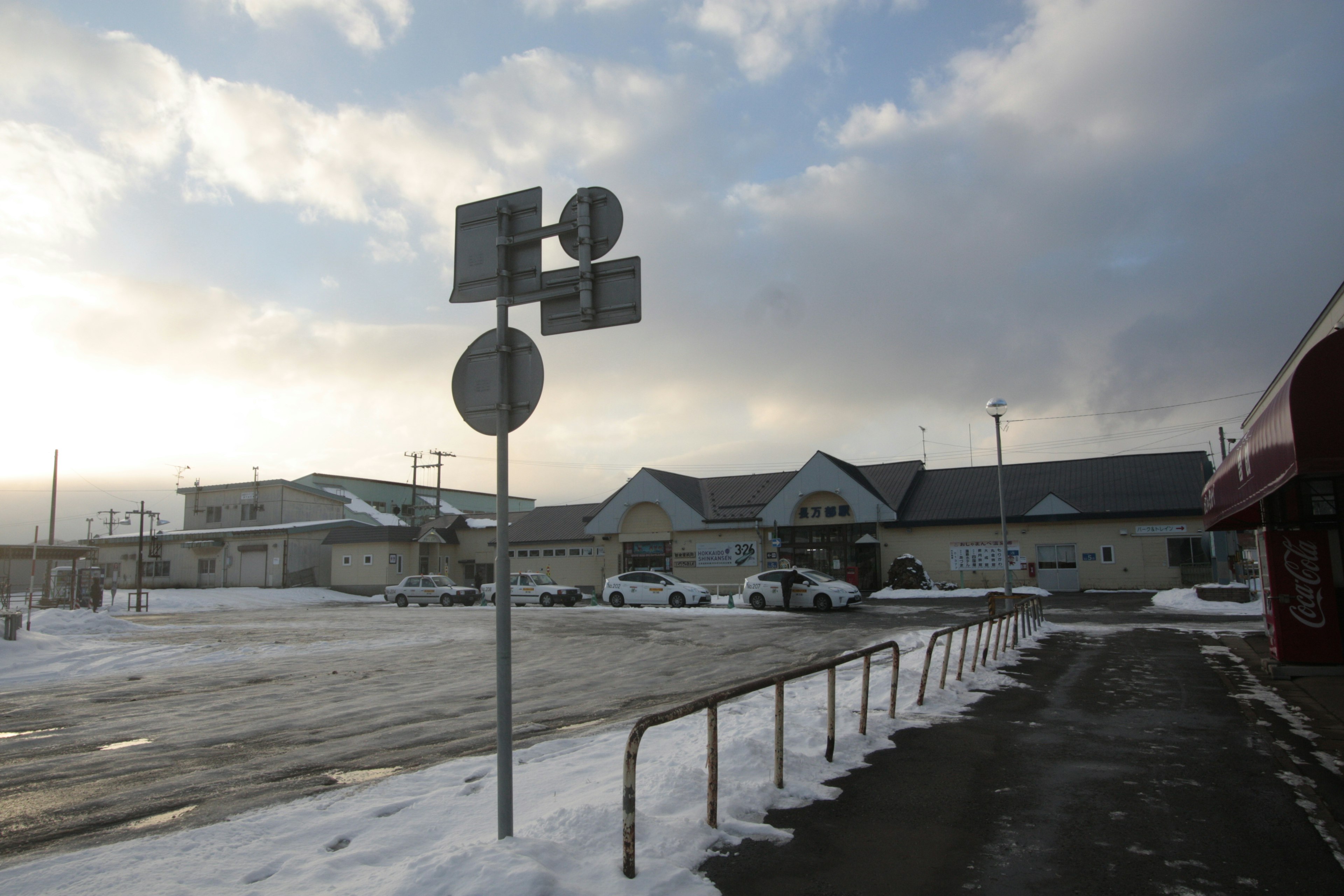 被雪覆蓋的停車場，背景有交通標誌和建築