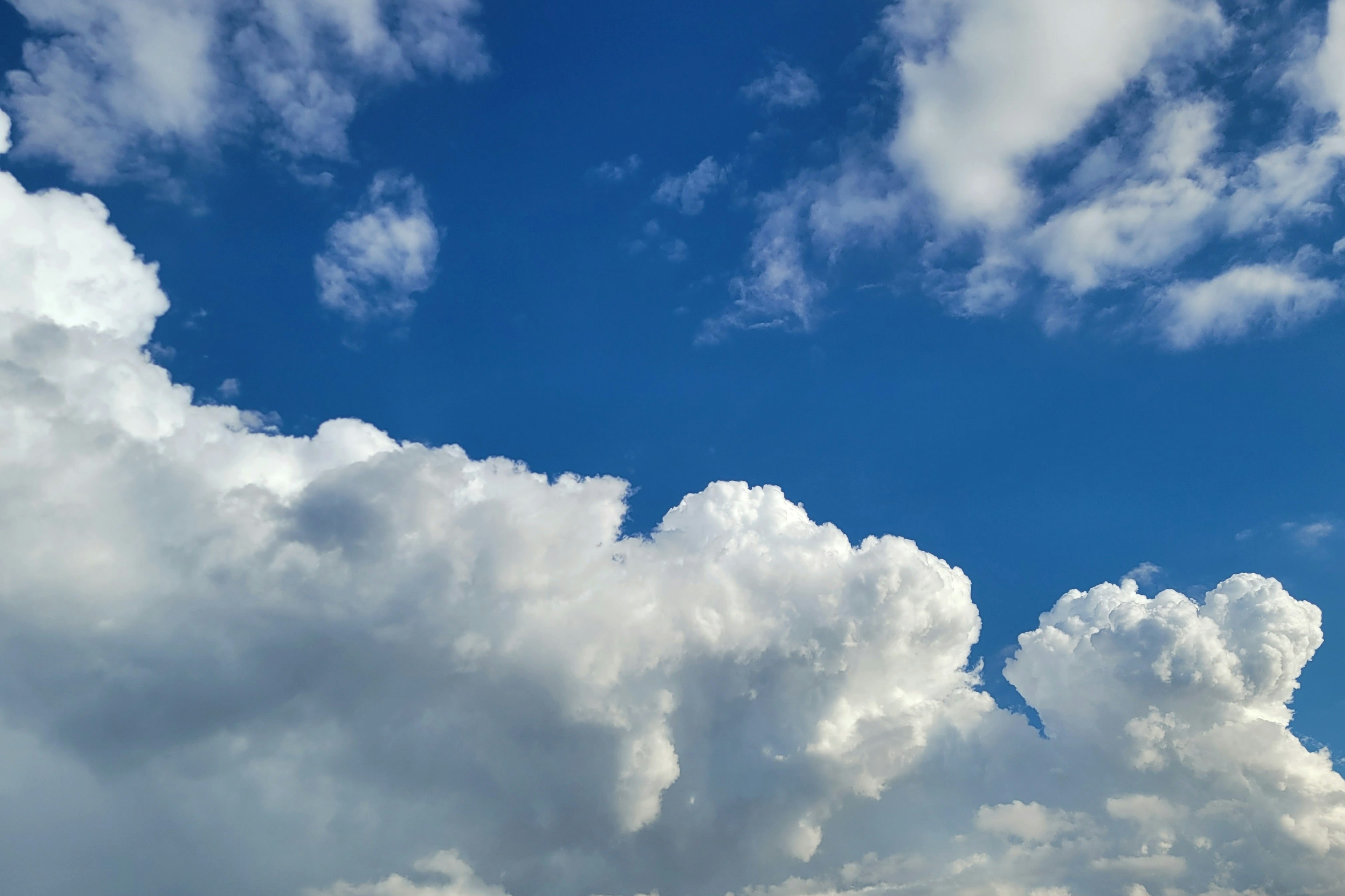 A scenic view featuring a blue sky with fluffy white clouds