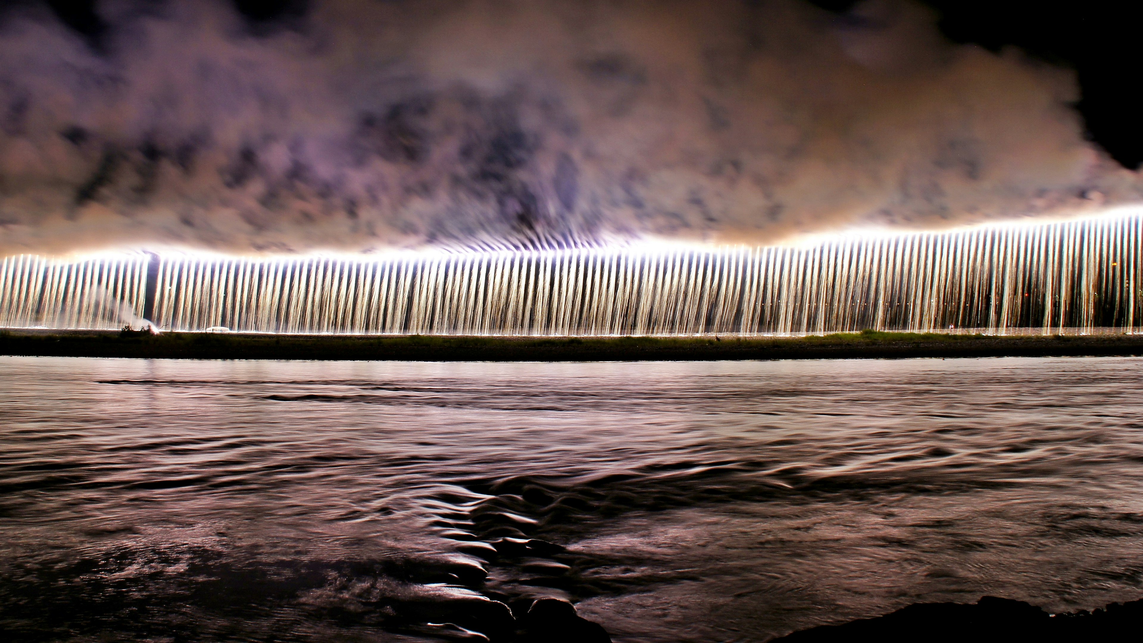 Scène nocturne d'une cascade éclairée par des lumières vives