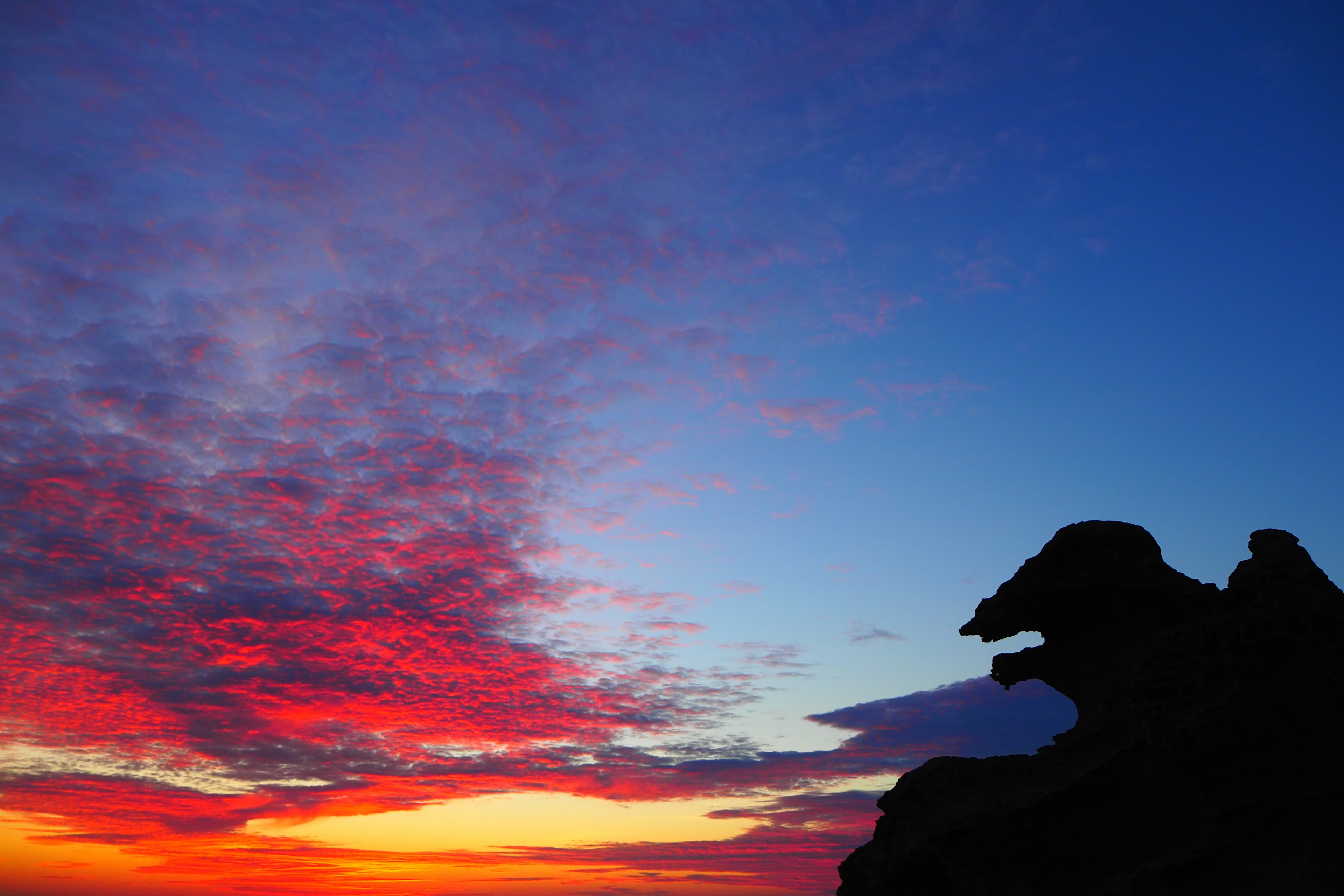 Impresionante paisaje con cielo al atardecer y silueta de roca