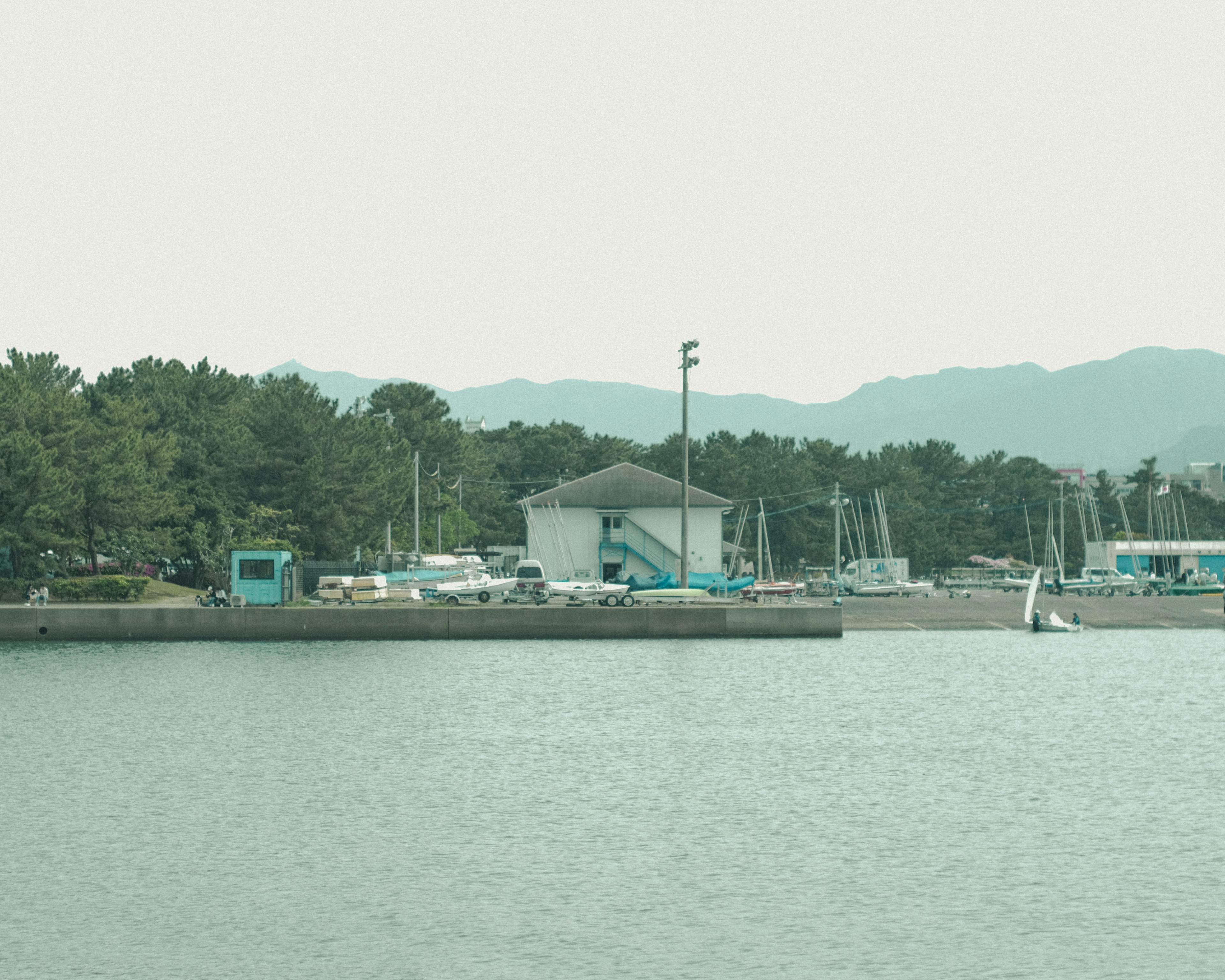 海の近くにある白い建物とボートの風景