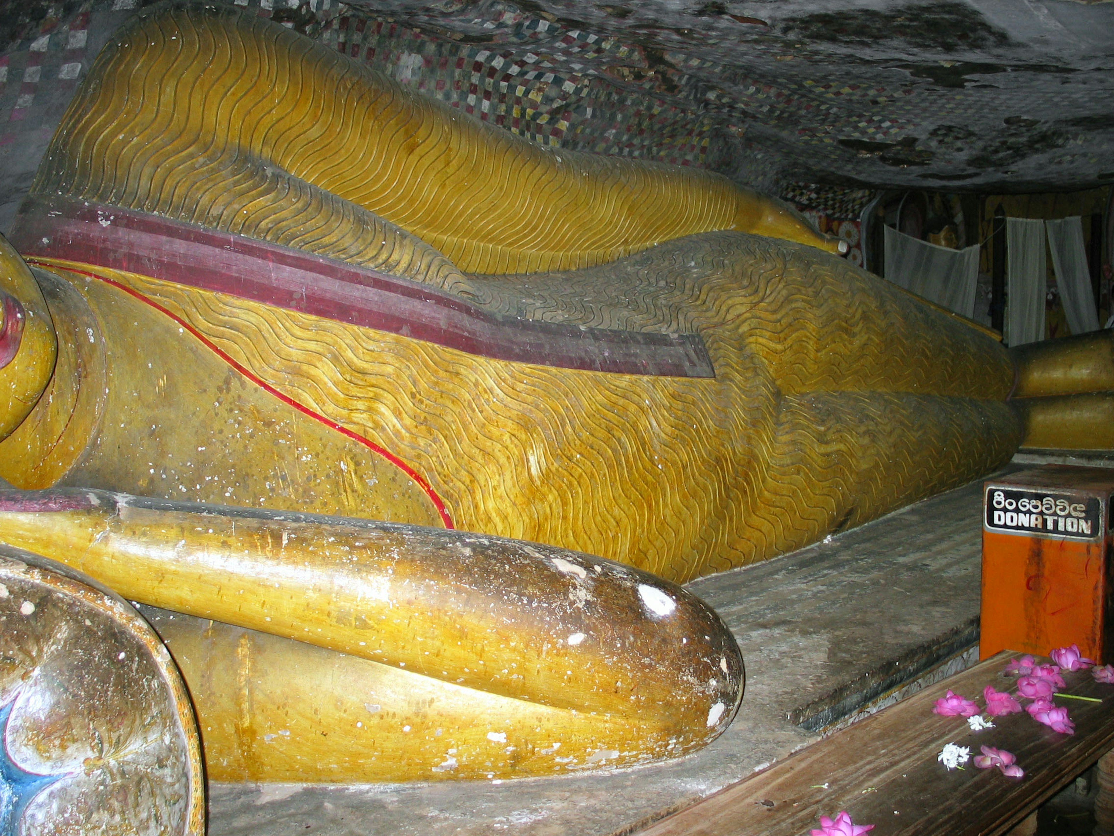 Statua del Buddha sdraiato dorato in una grotta