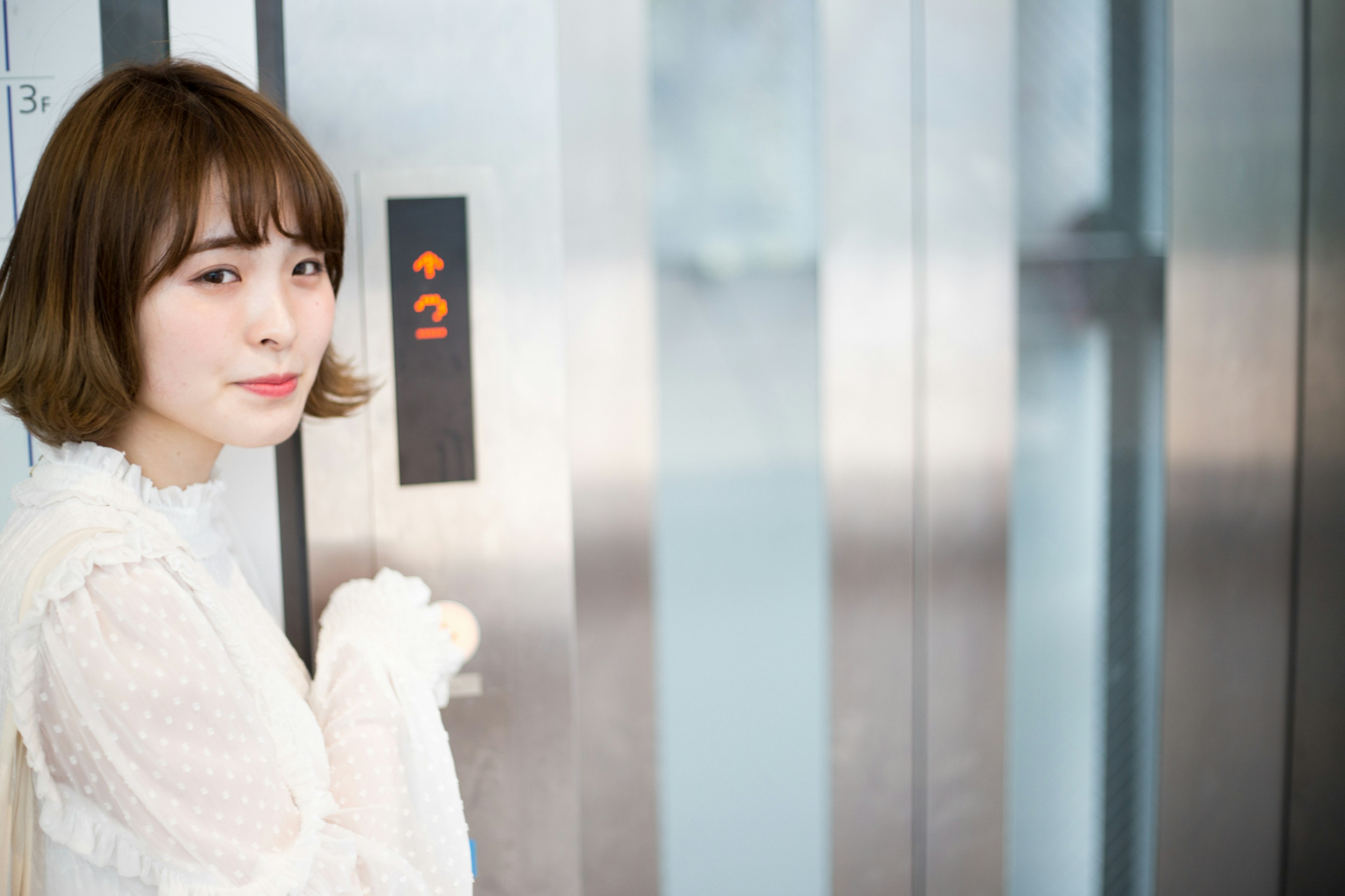 A woman smiling in front of an elevator