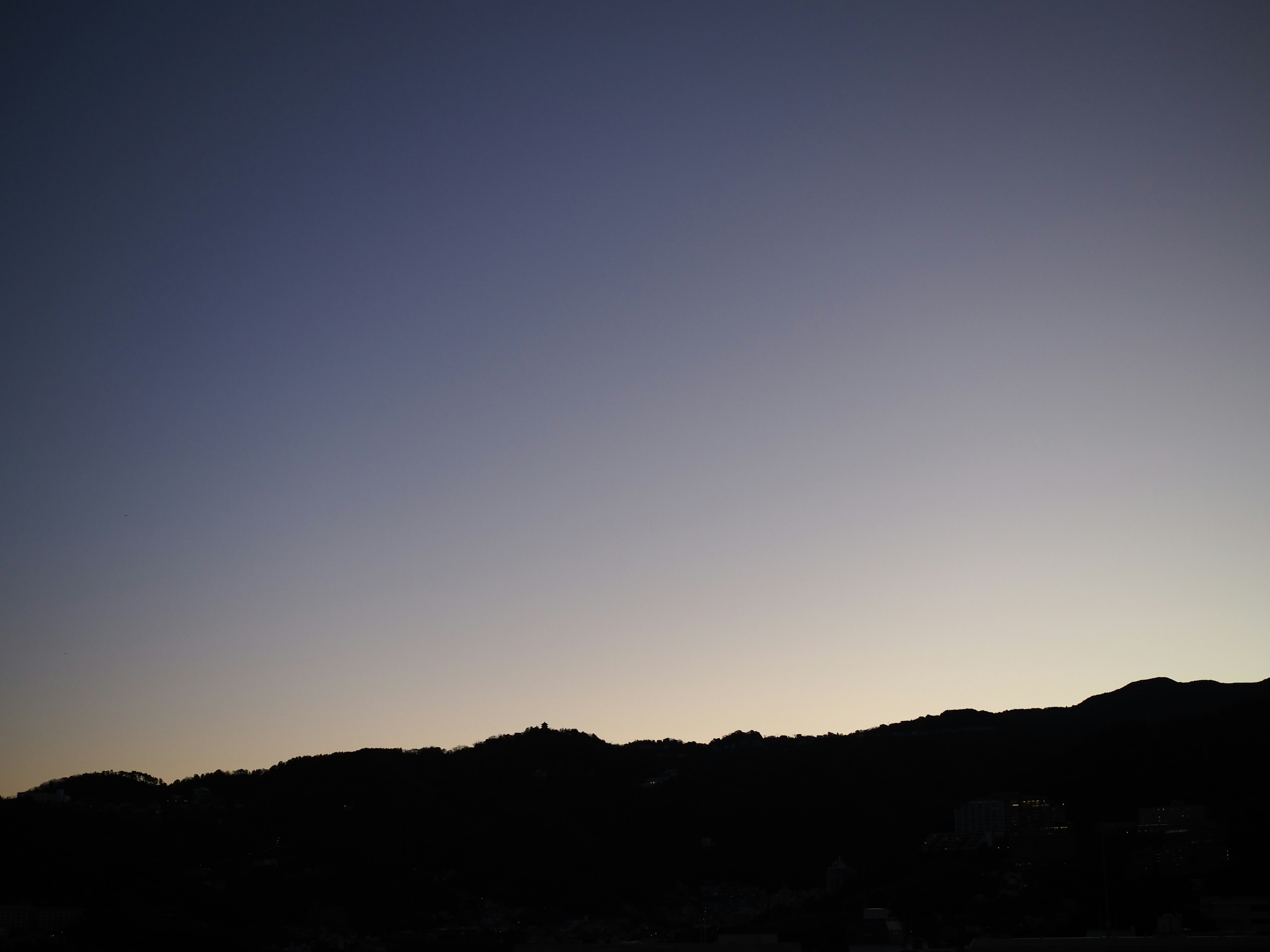 夕暮れの山々のシルエットが映る空のグラデーション