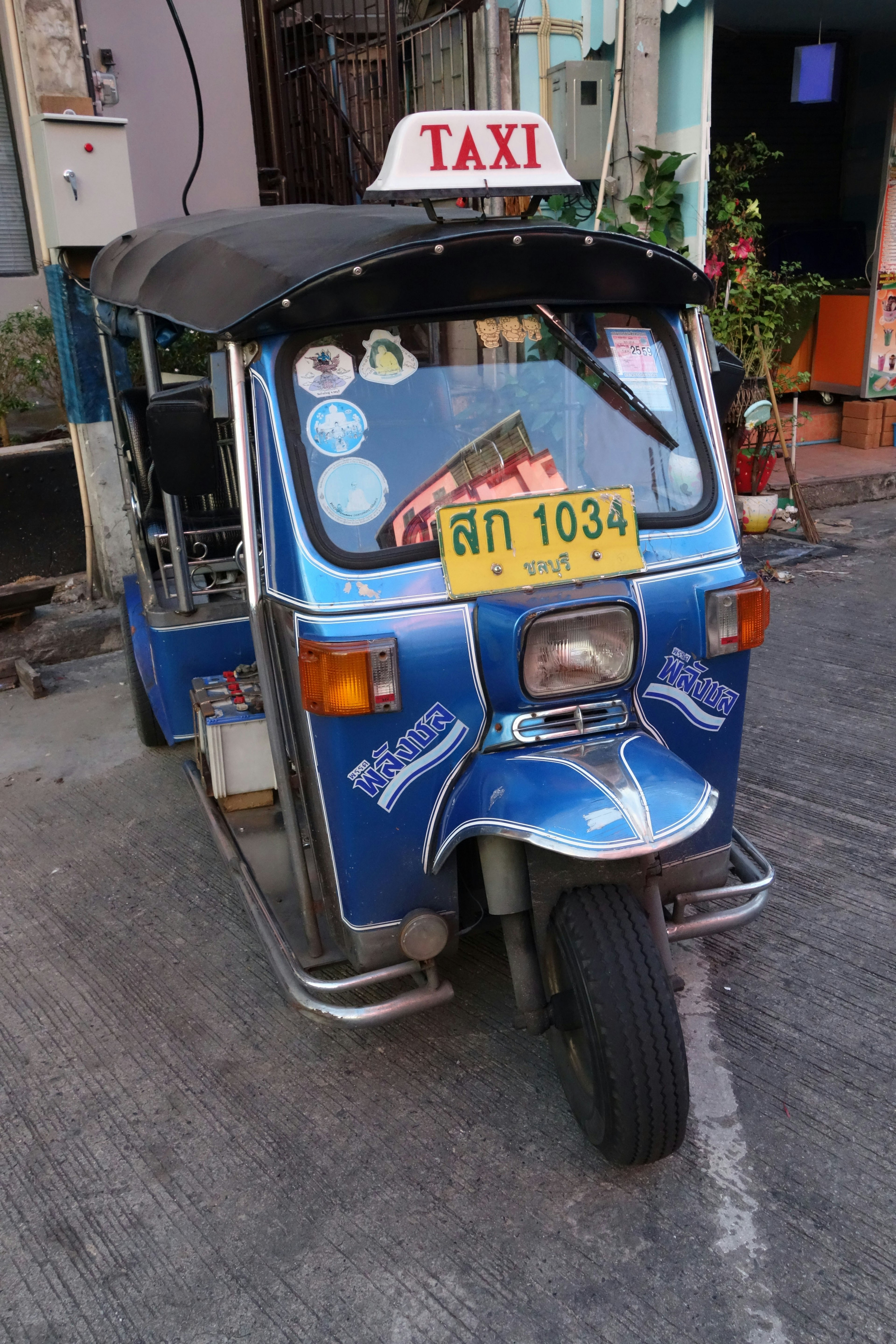 Tuk-tuk taksi biru diparkir di jalan