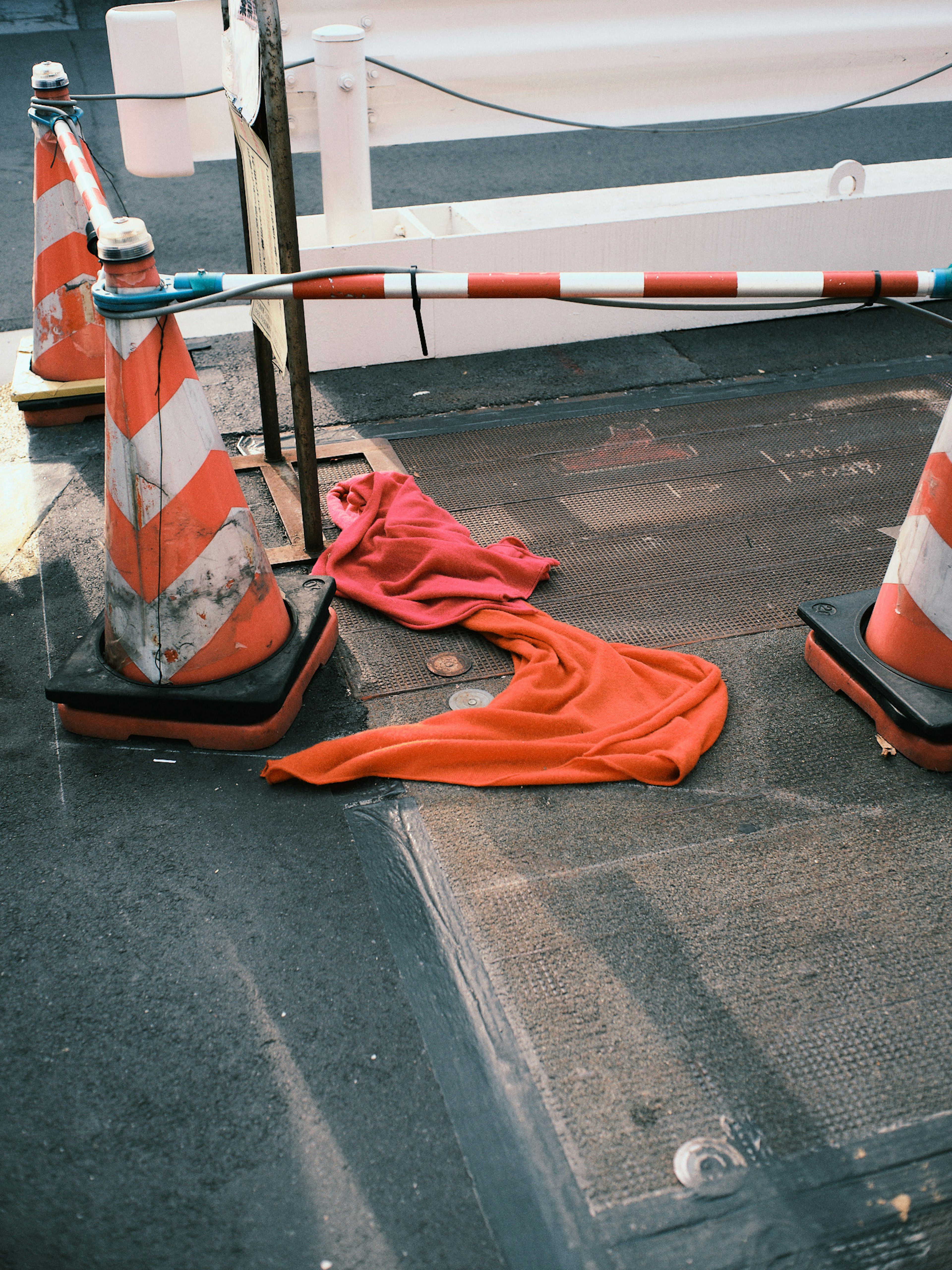 Cônes de circulation orange et blanc avec un tissu rouge sur le sol