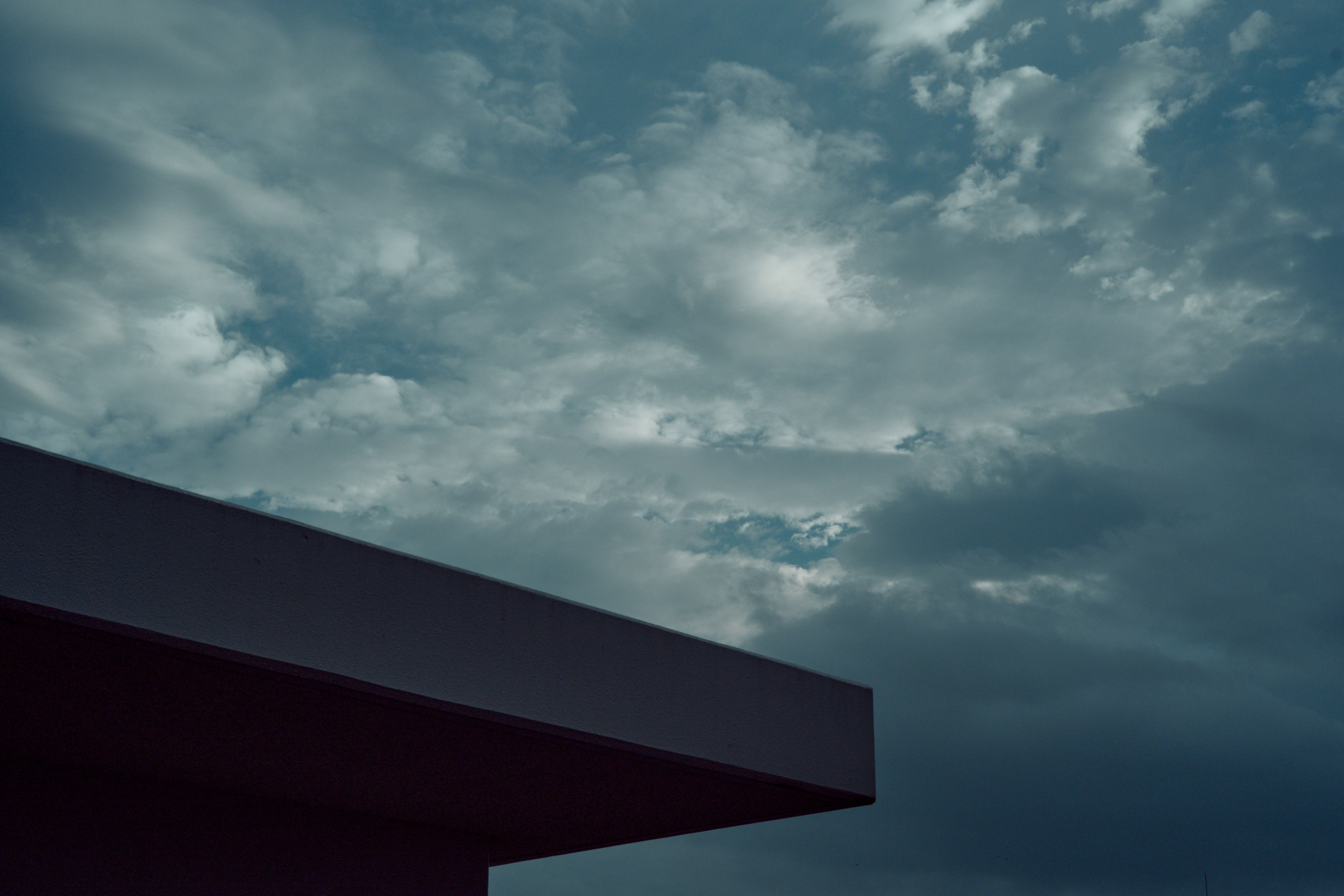 Cloudy sky with dark clouds and a roof edge