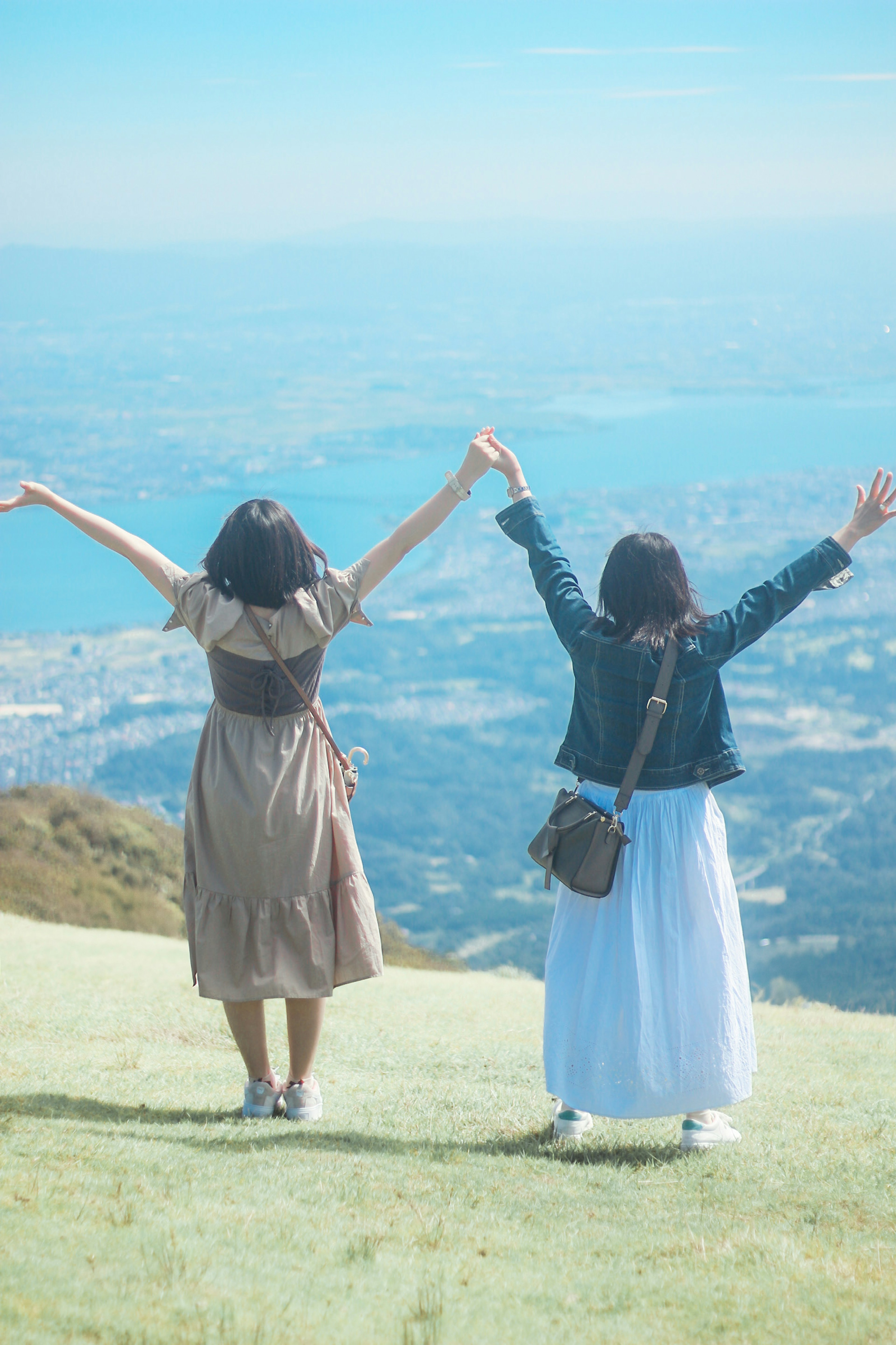 Two women raising their hands enjoying the view