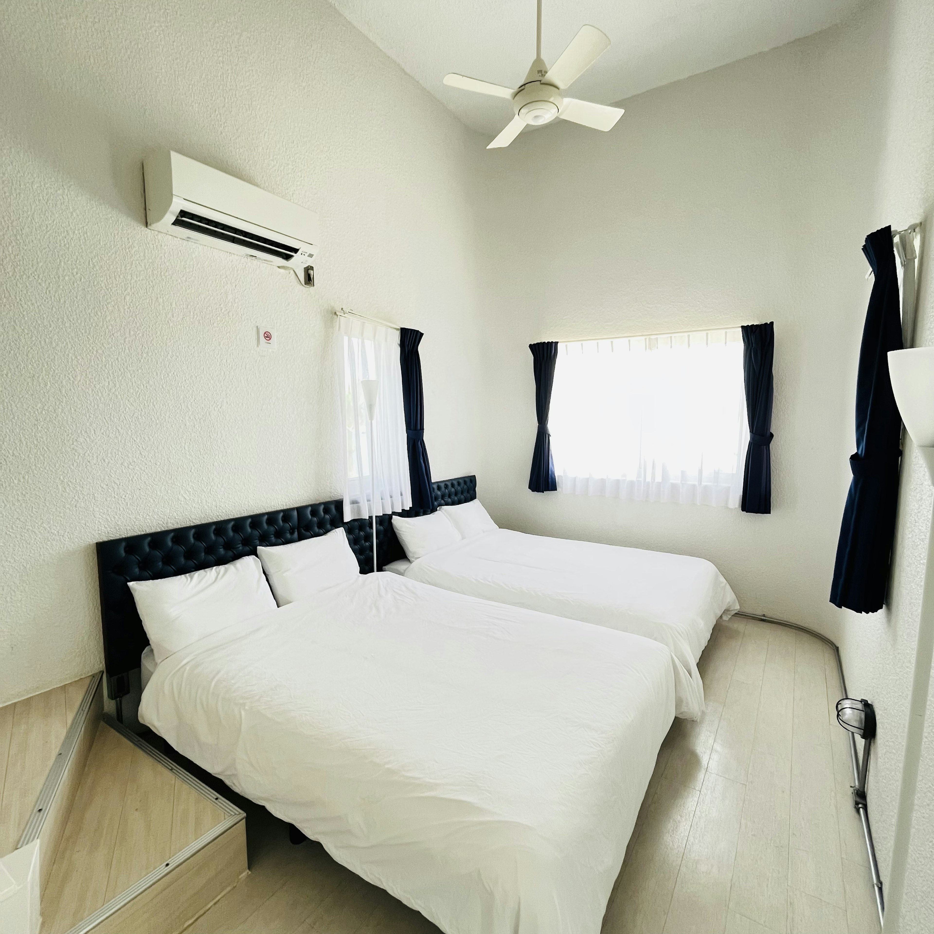 Bright and simple bedroom with two beds and window curtains