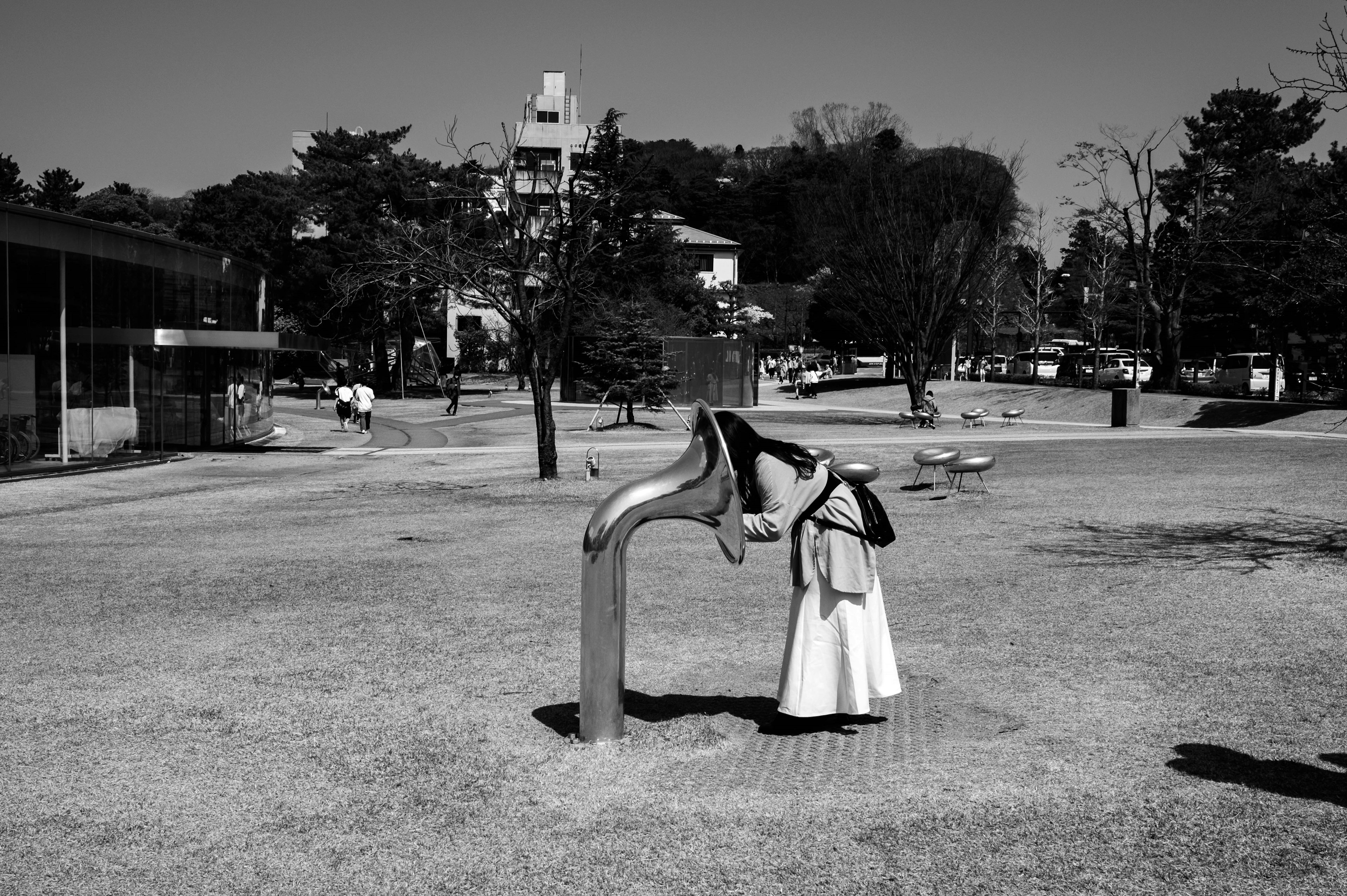 Ein Mädchen in einem weißen Kleid, das an einem Brunnen in einem Park spielt