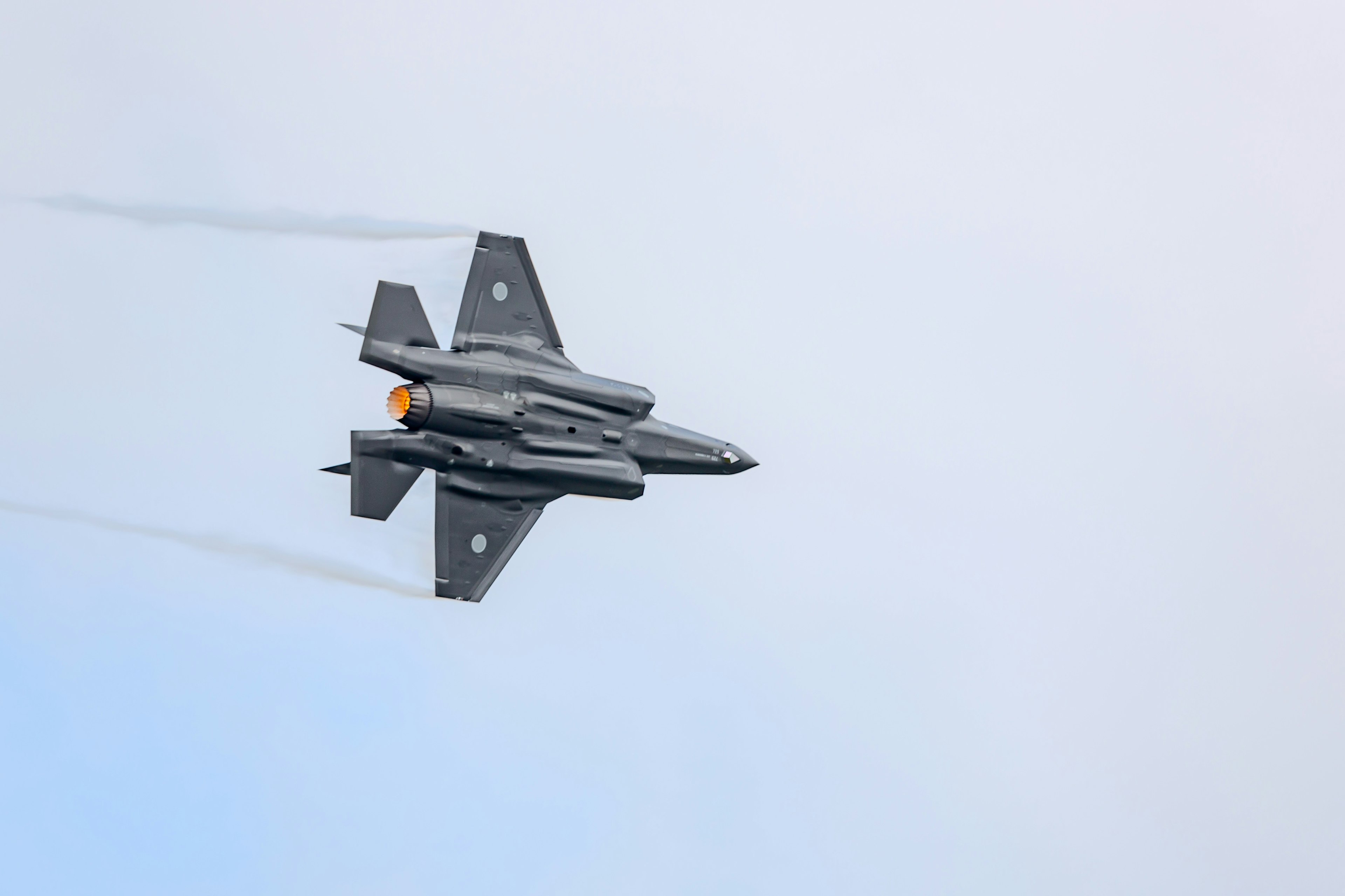 A fighter jet flying through a blue sky