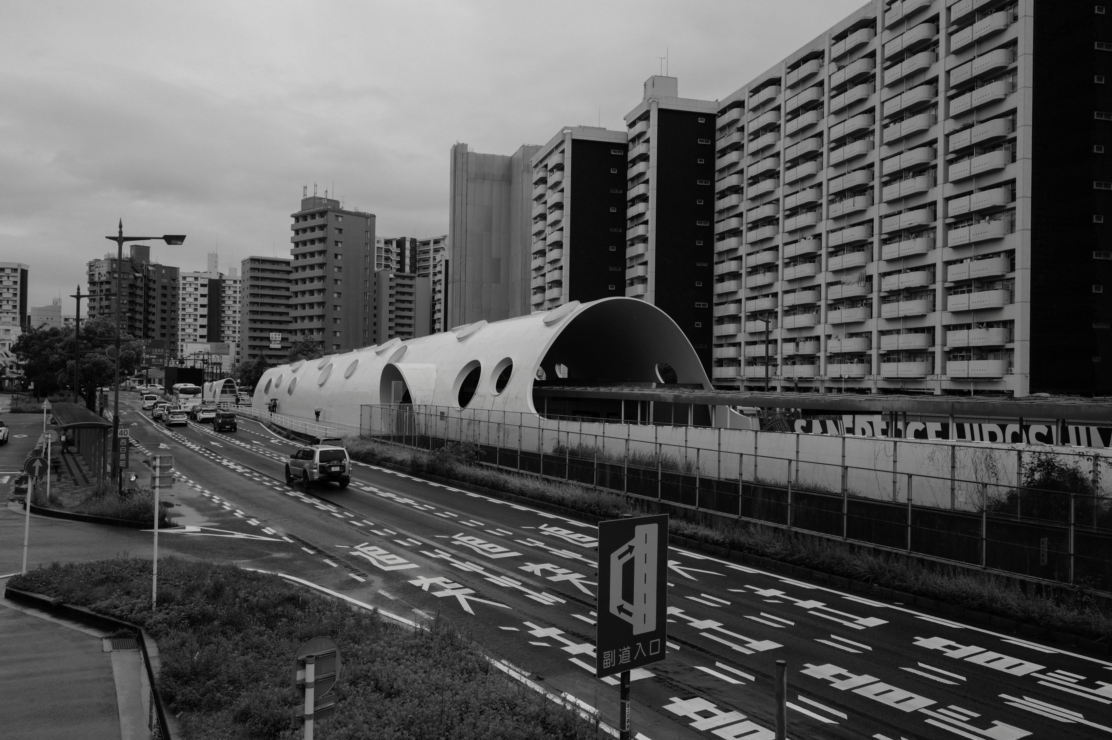 モノクロの都市風景にある未来的な交通トンネルと高層ビル