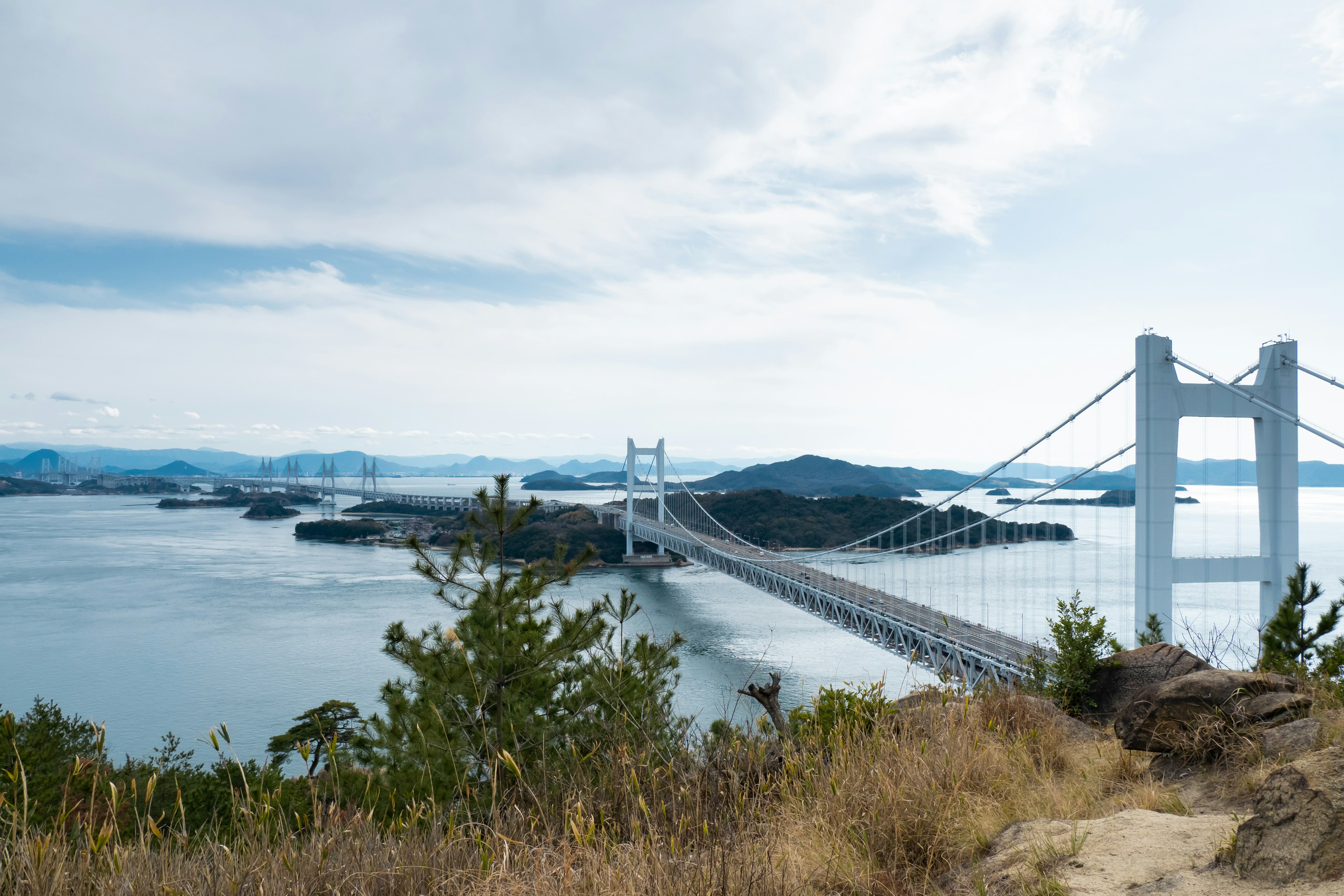 一座风景如画的桥横跨水面，远处是岛屿