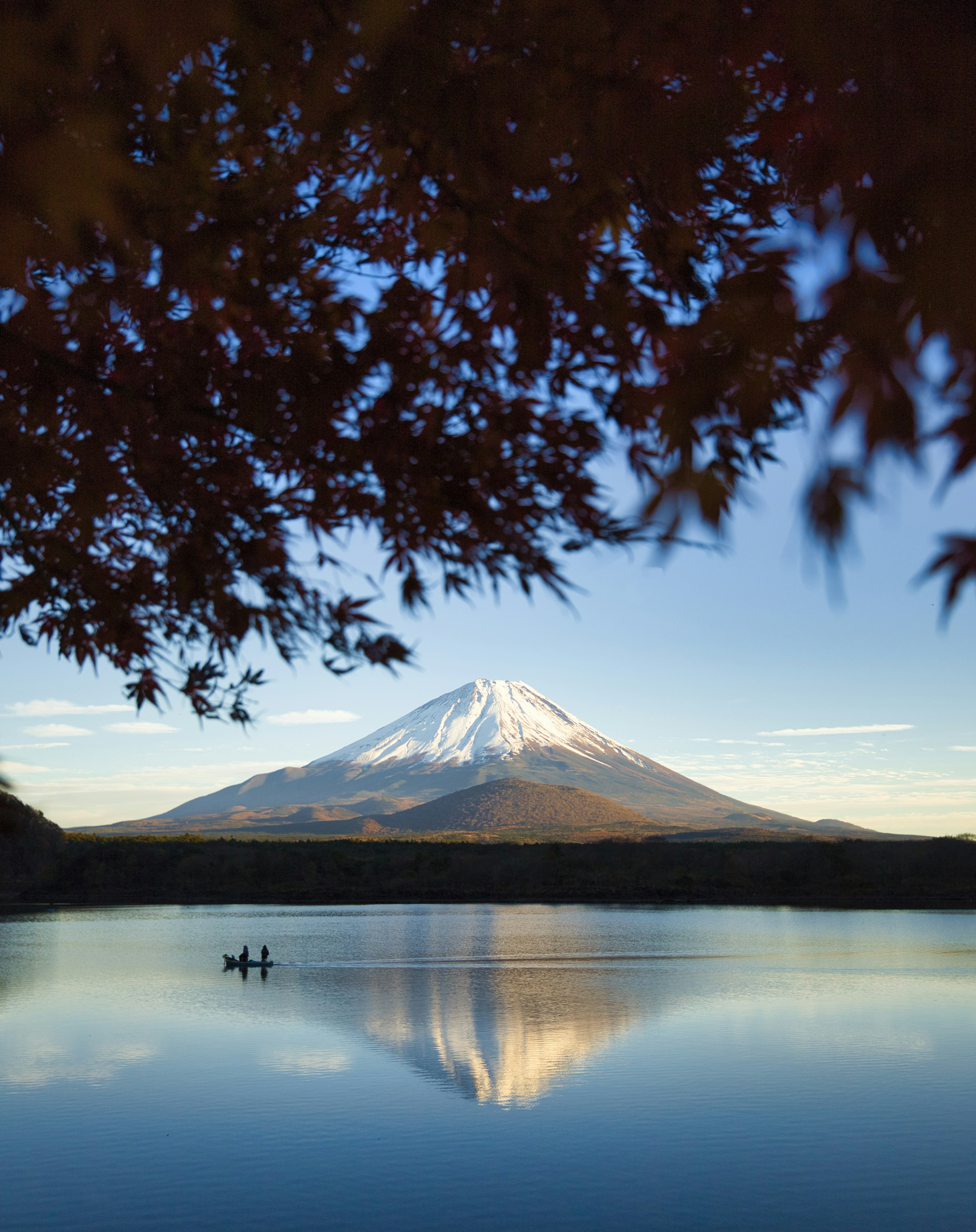 富士山が湖に映る美しい風景　紅葉の葉がフレームに入っている