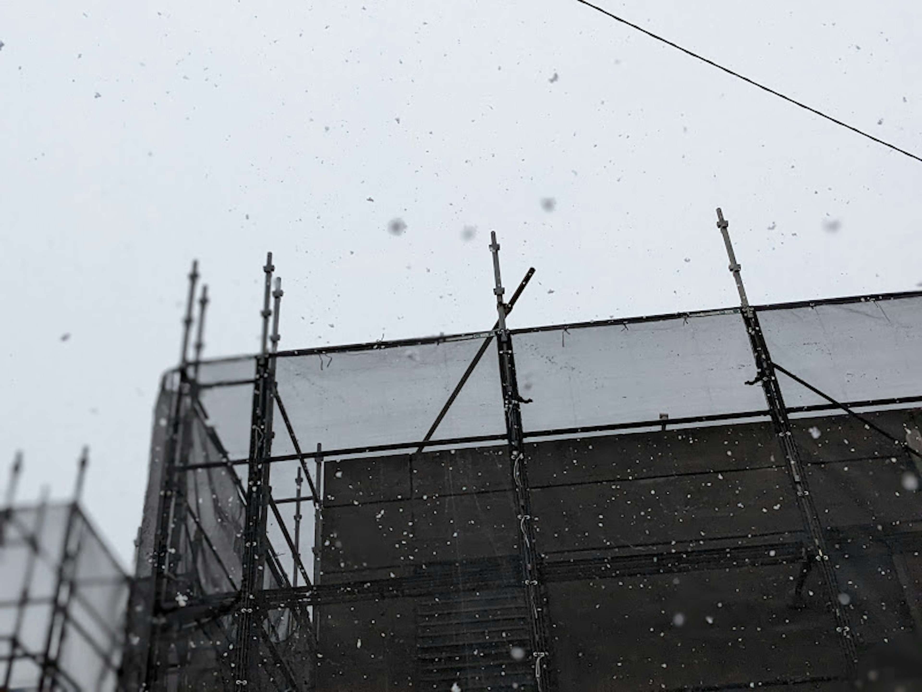 Échafaudage d'un bâtiment sous la neige et ciel nuageux