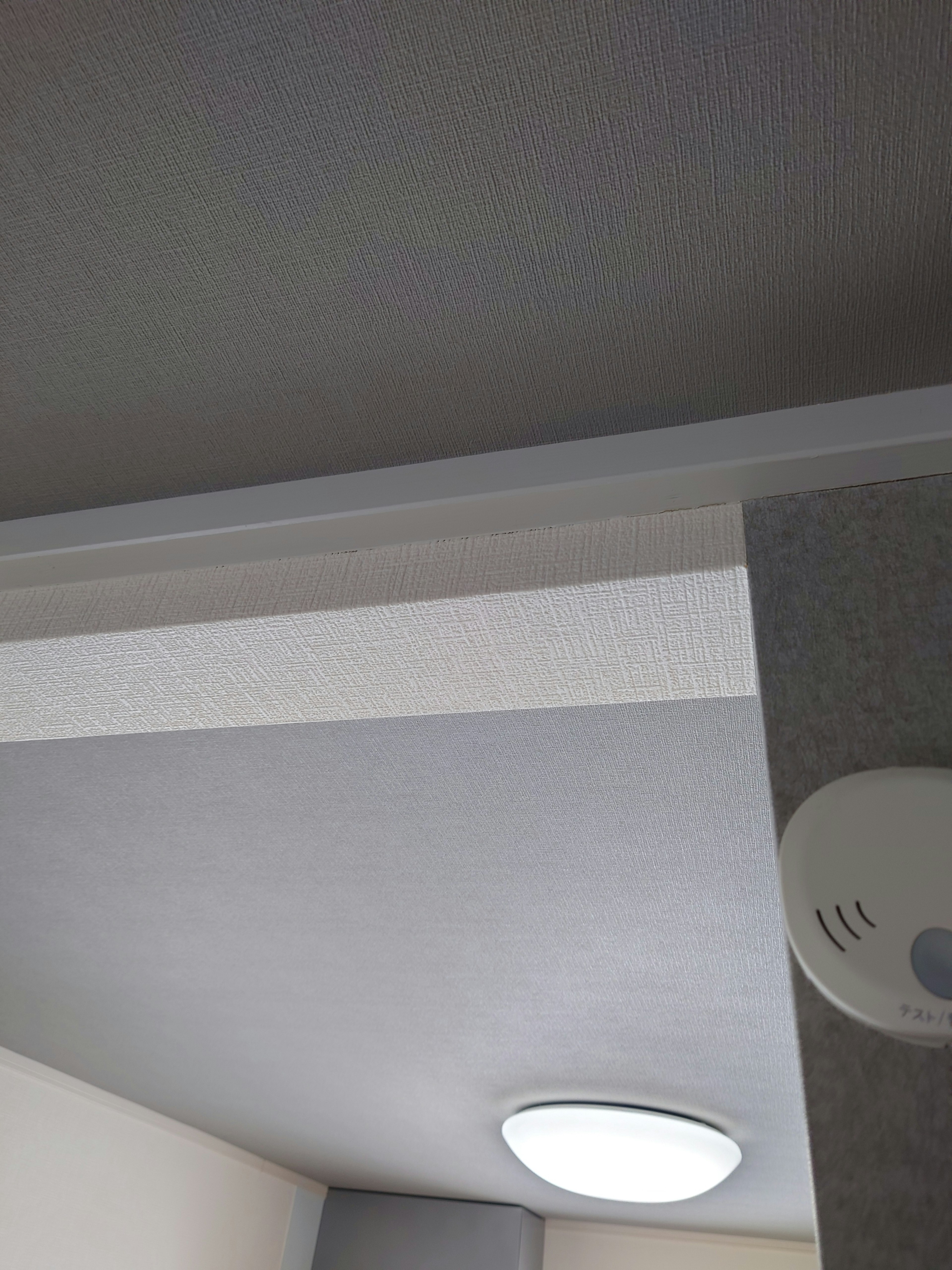 Image of a room corner featuring a white ceiling and simple lighting