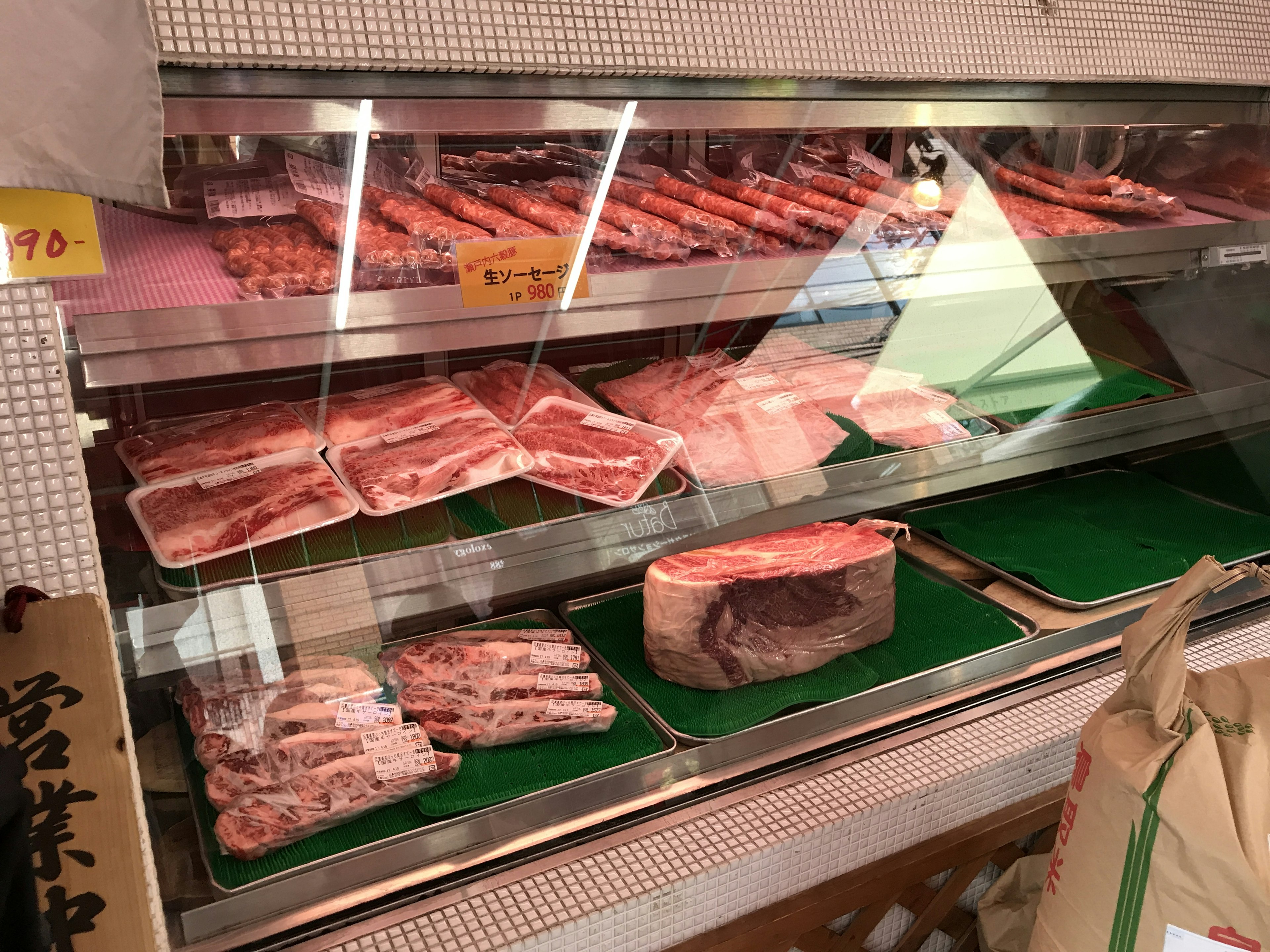 Vitrine einer Metzgerei mit frischem Fleisch und verpackten Produkten