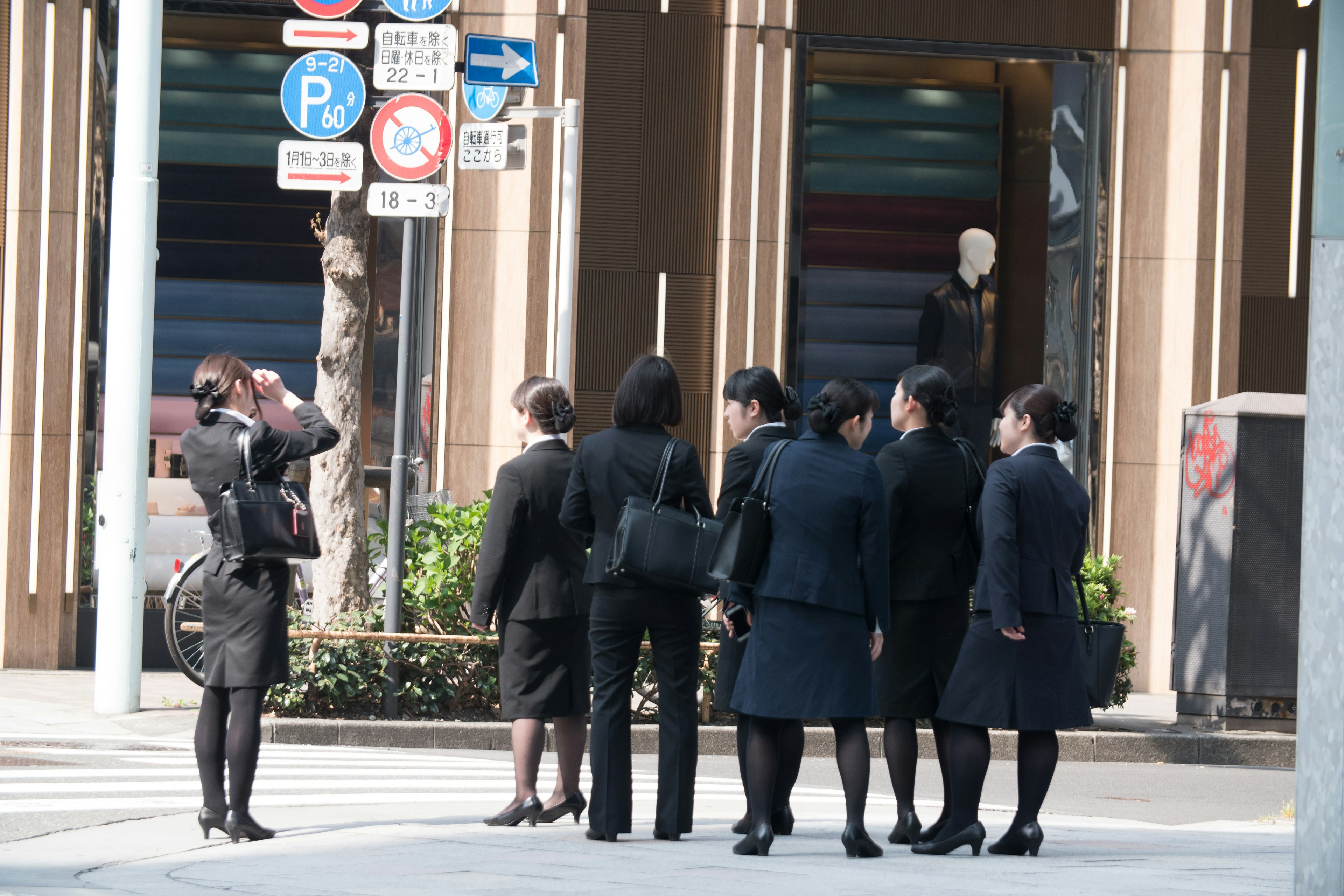 一群穿著商務套裝的女性聚集在街角