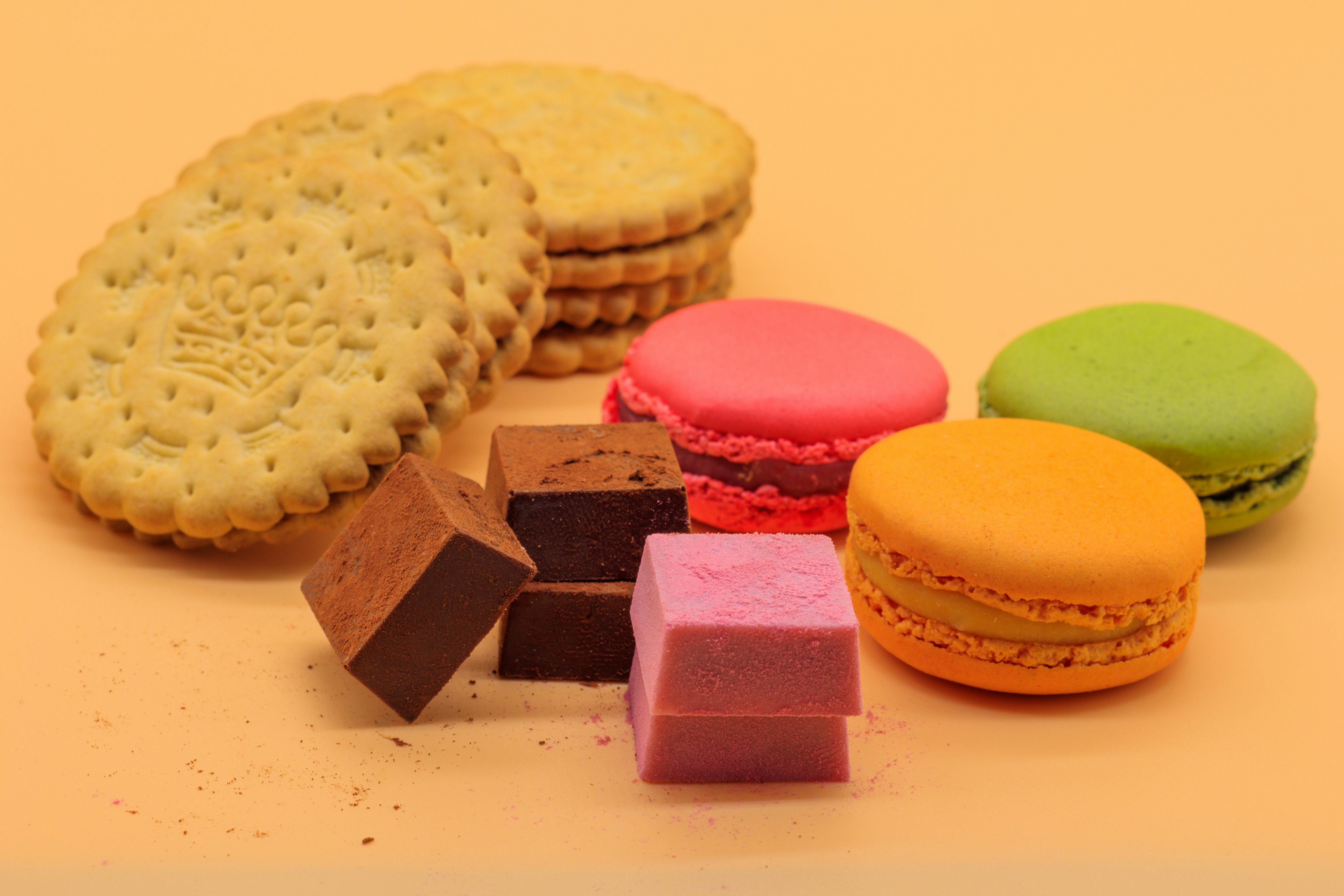 Colorful macarons and chocolate squares arranged on a plate