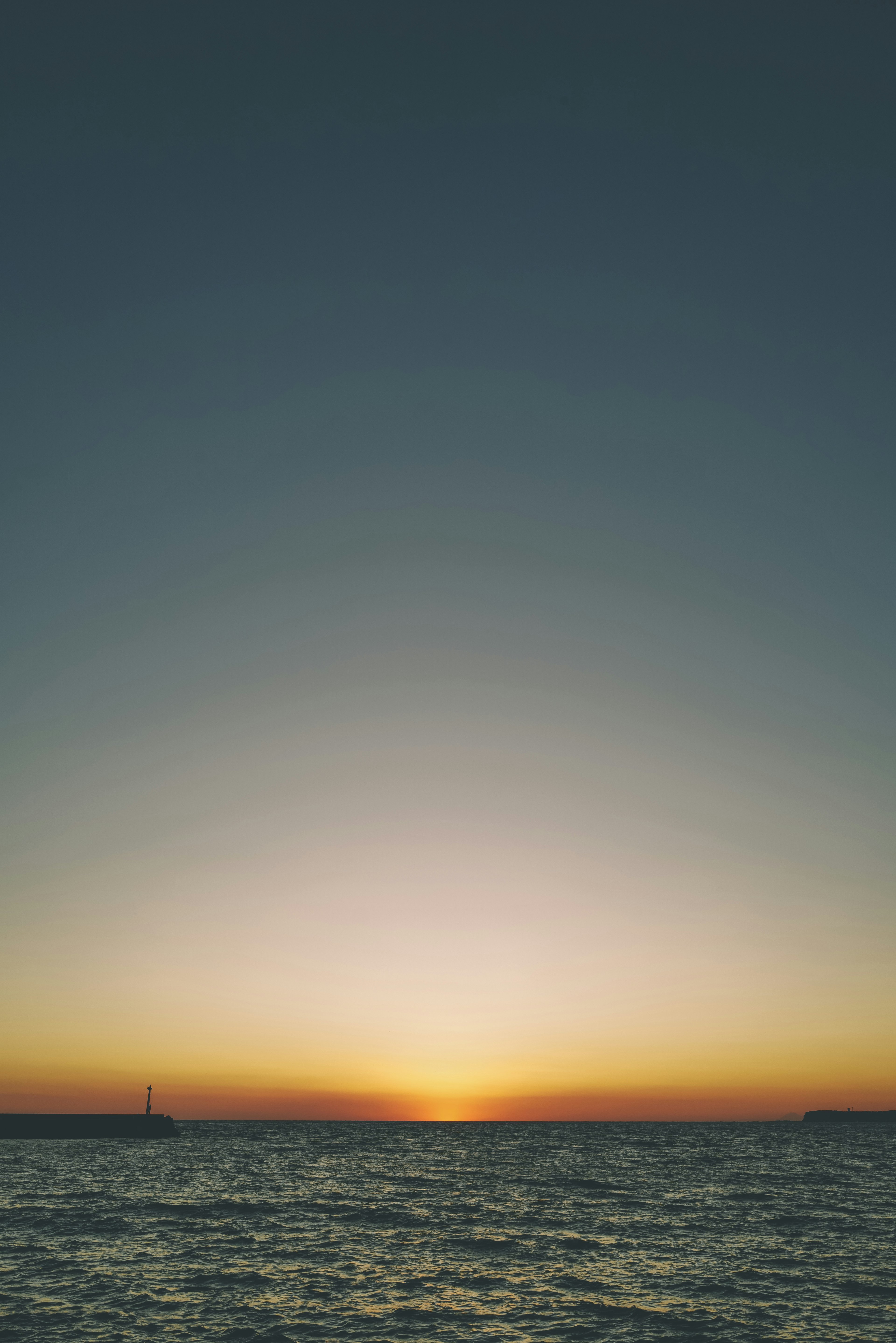 Sonnenuntergang über ruhigem Wasser mit einem Farbverlauf am Himmel