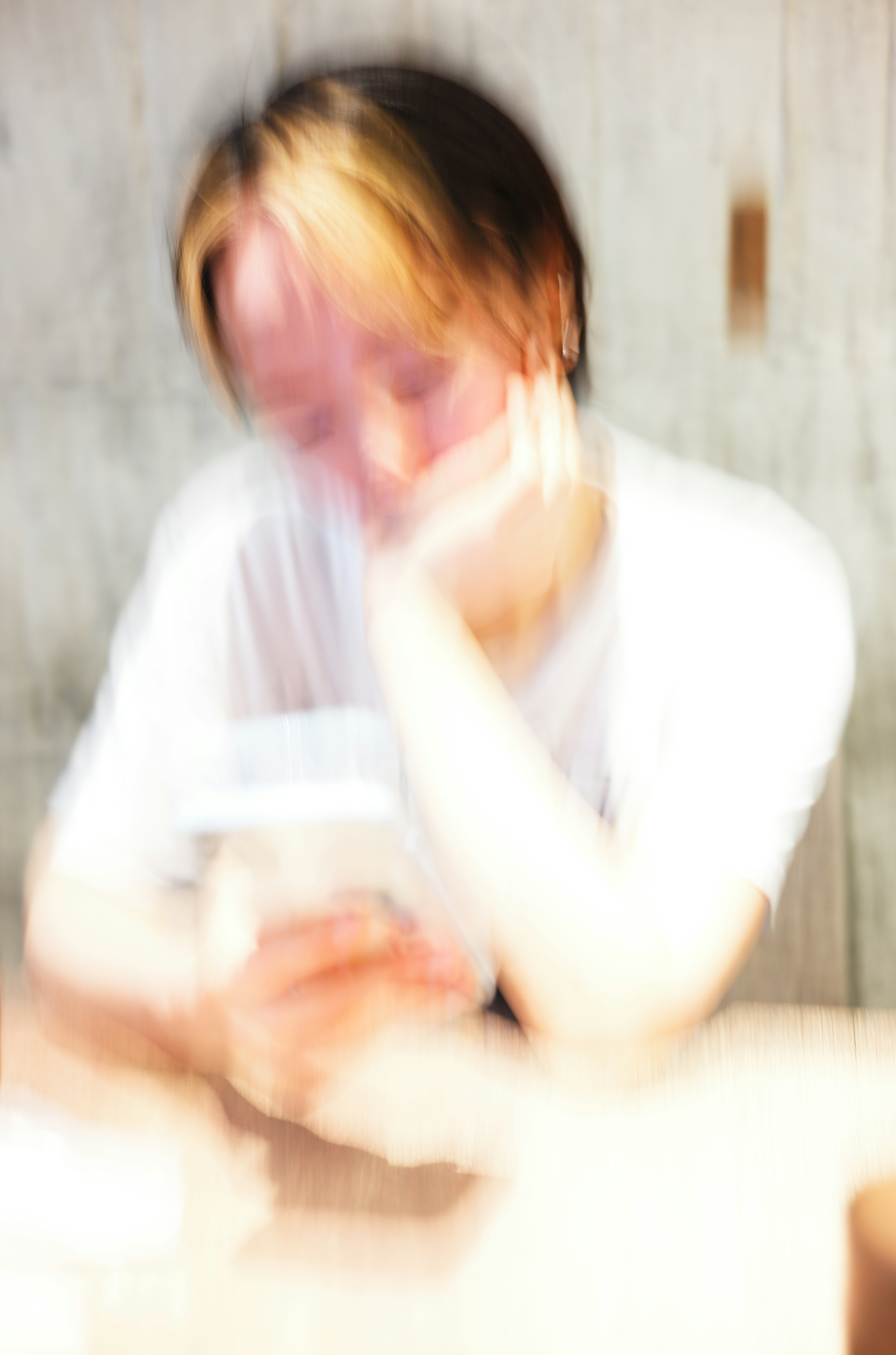 A blurred figure holding a smartphone with a soft background