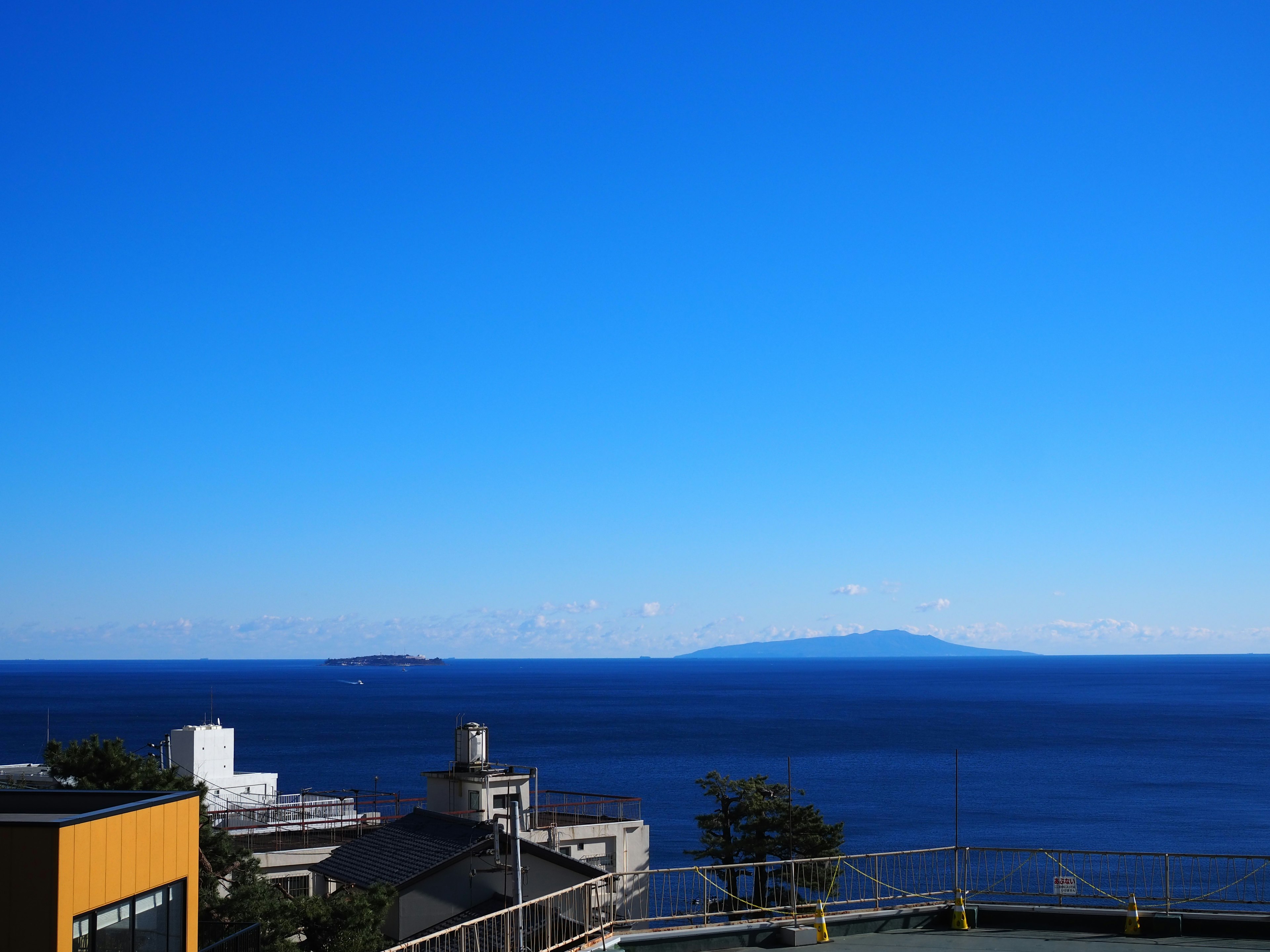 Ciel bleu lumineux au-dessus d'une mer calme avec des îles lointaines