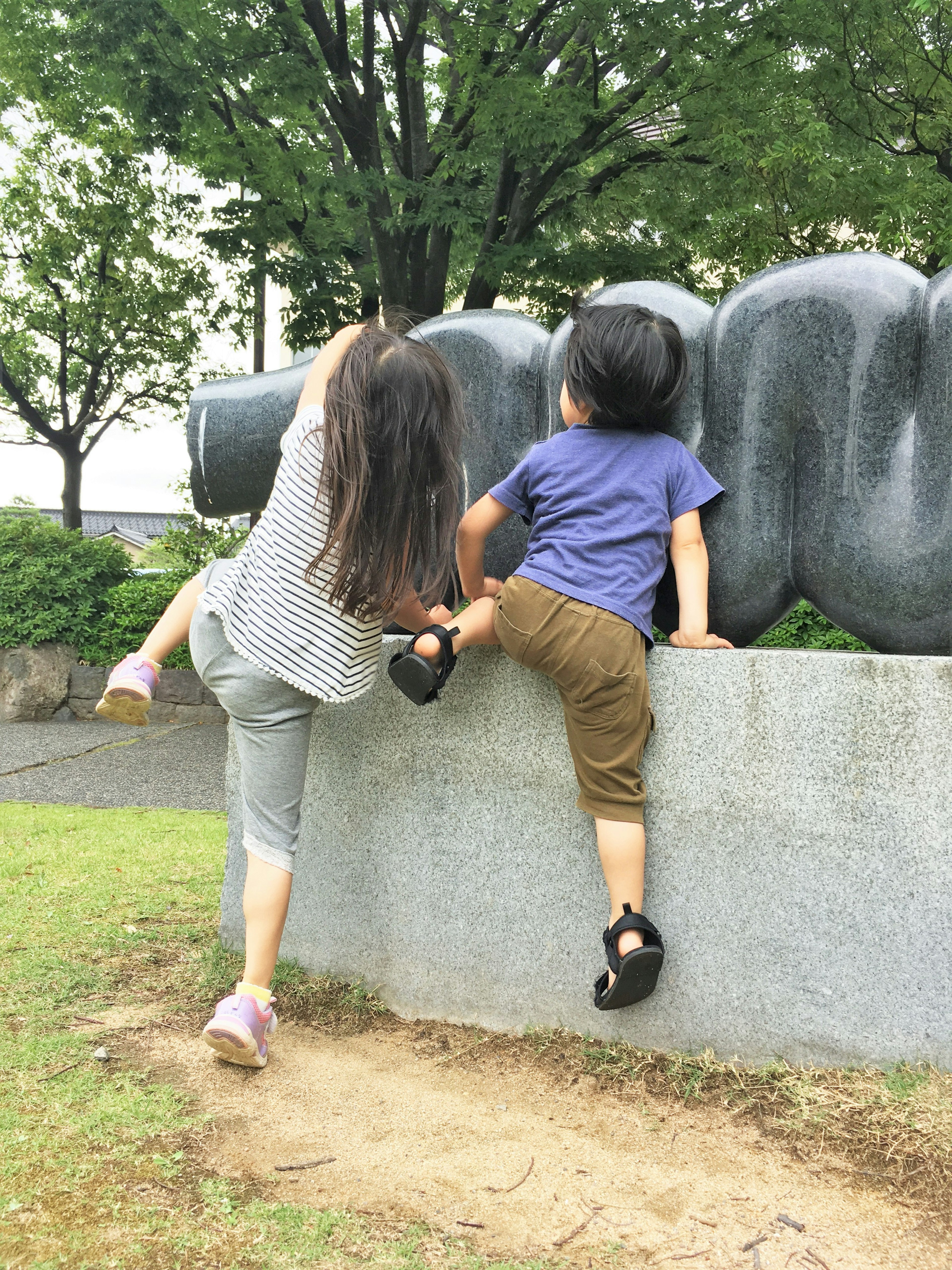 孩子們在公園裡爬上一座大雕塑