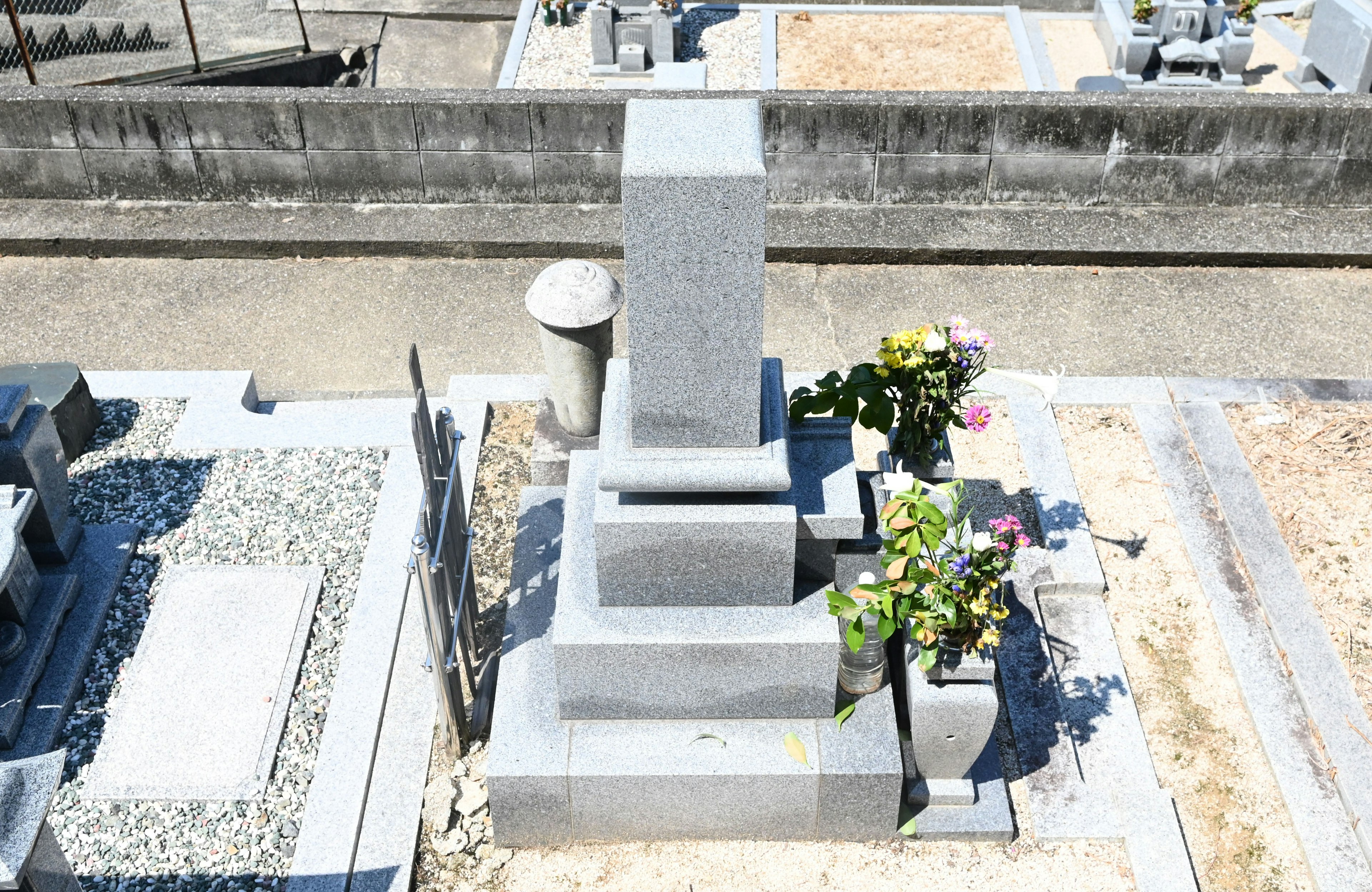 Gray tombstone viewed from above with floral arrangement