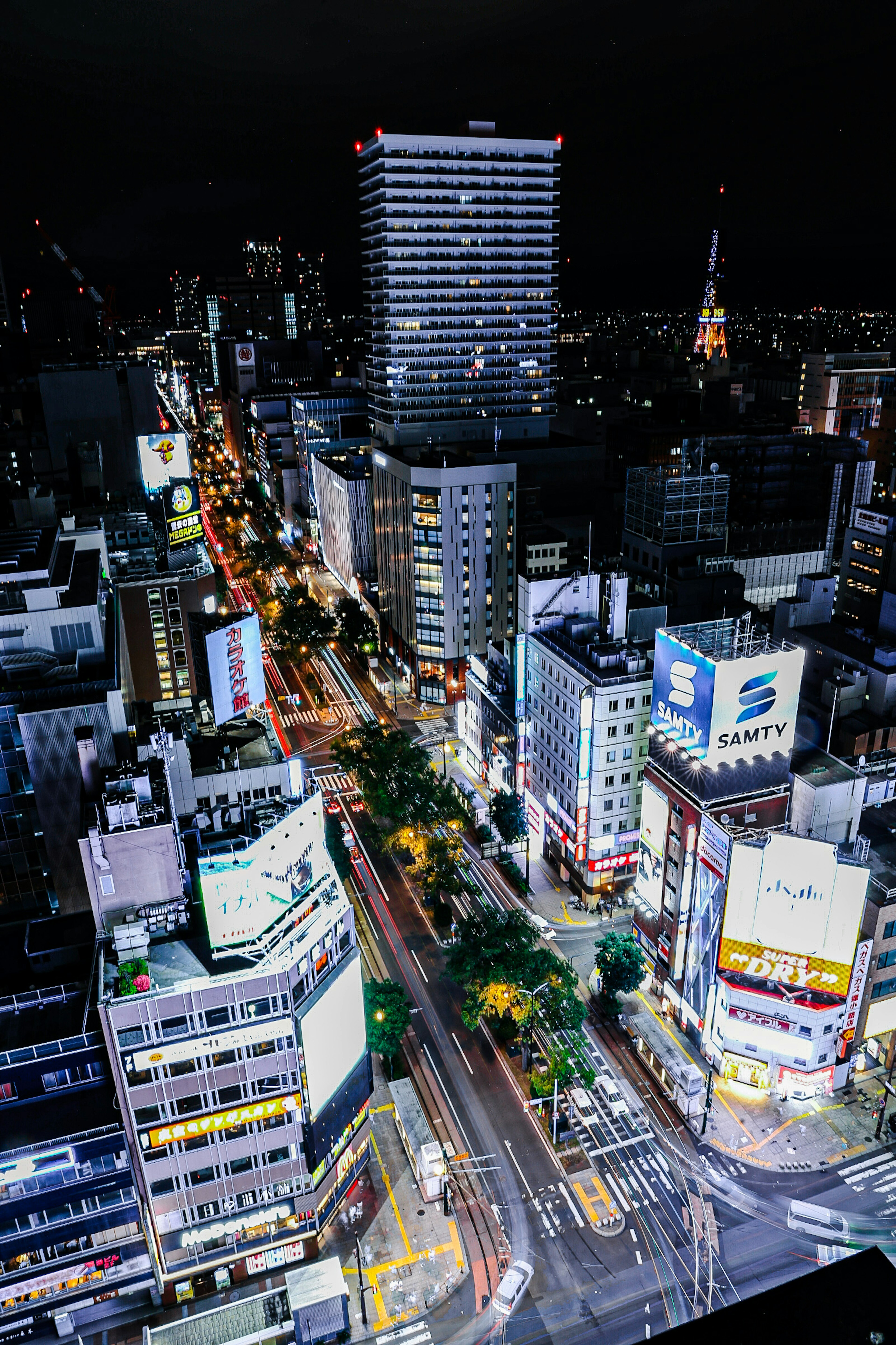 Night cityscape featuring tall buildings and bright billboards