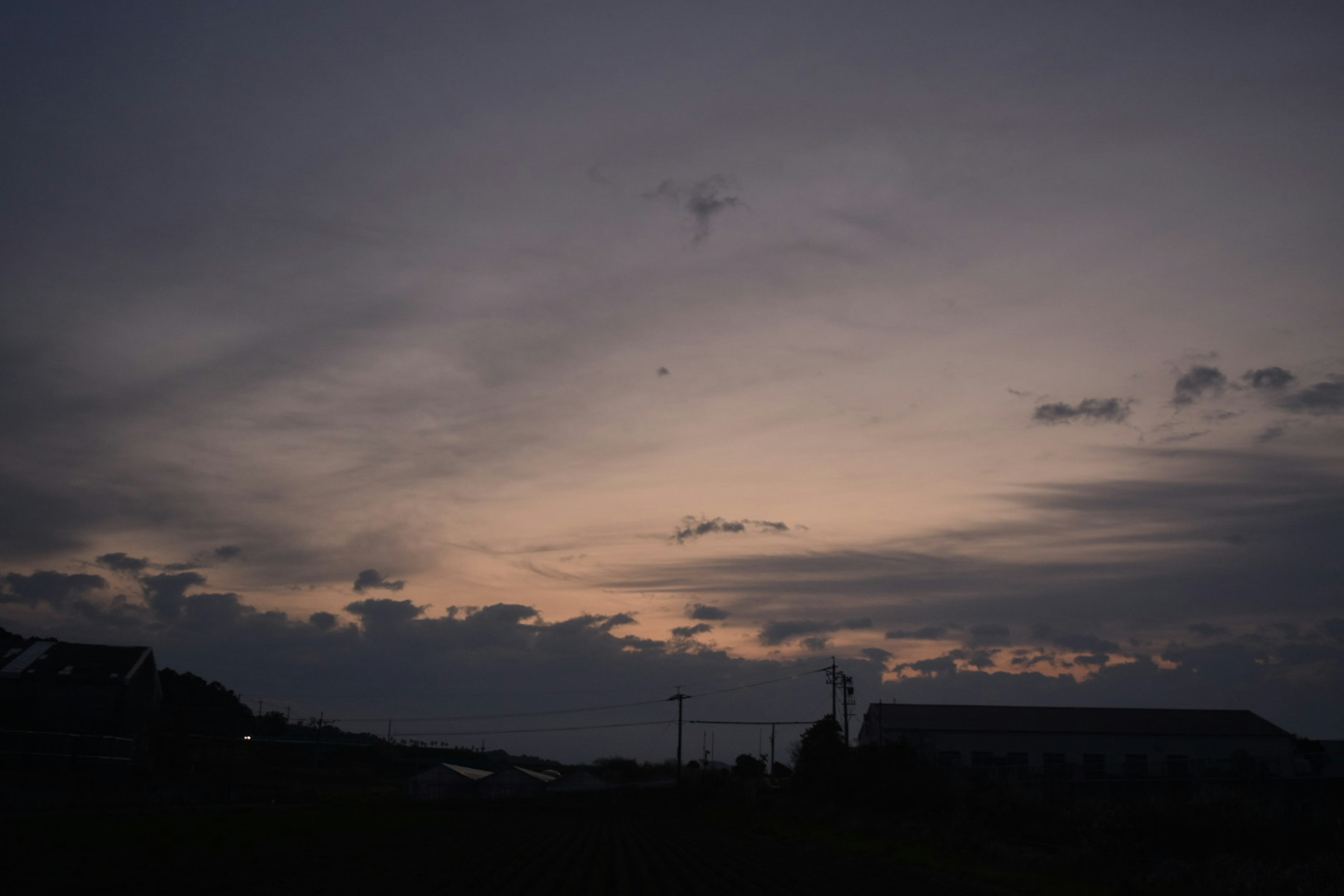 夕焼けの空と雲のシルエットが特徴的な風景