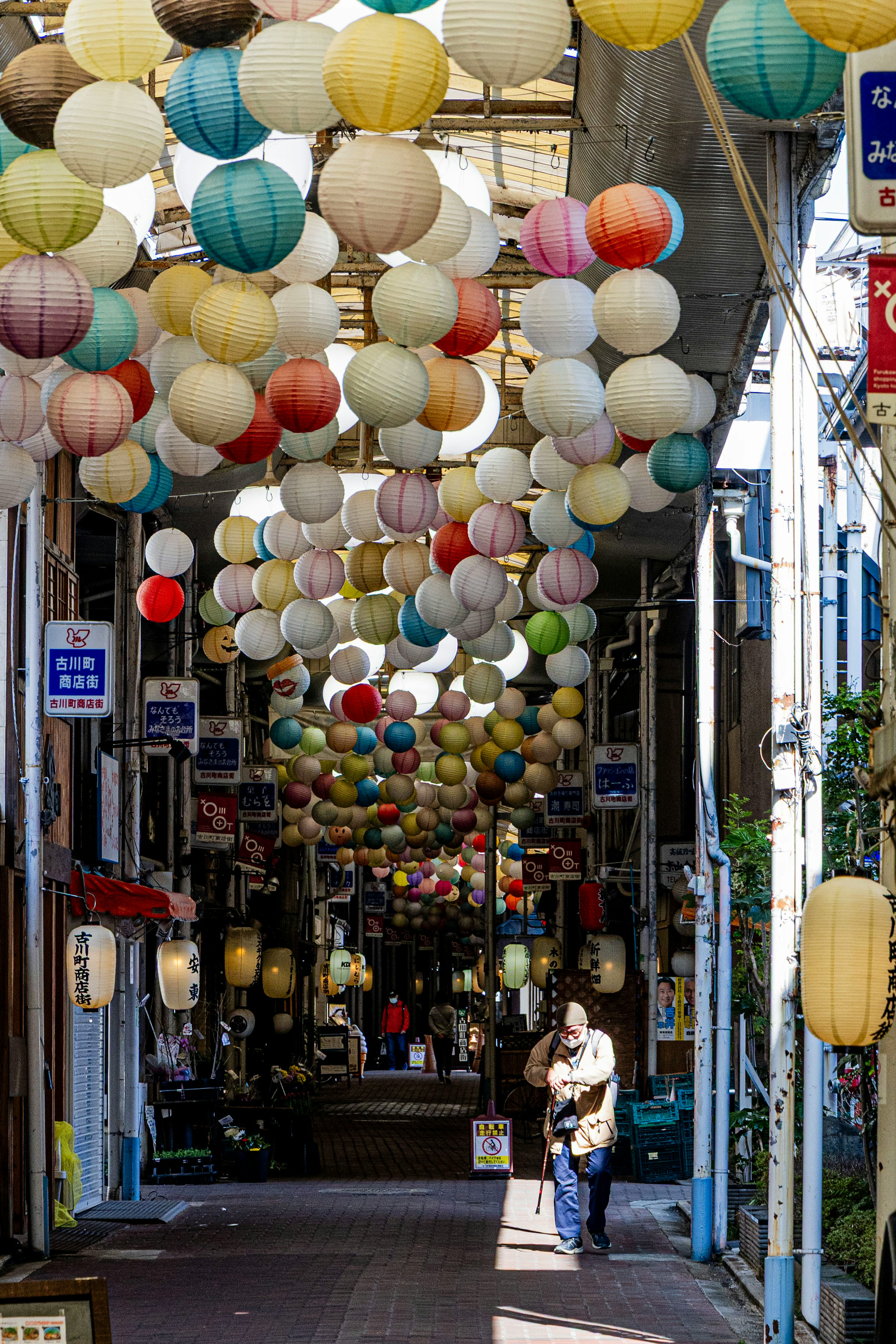 A vibrant street with colorful lanterns hanging overhead