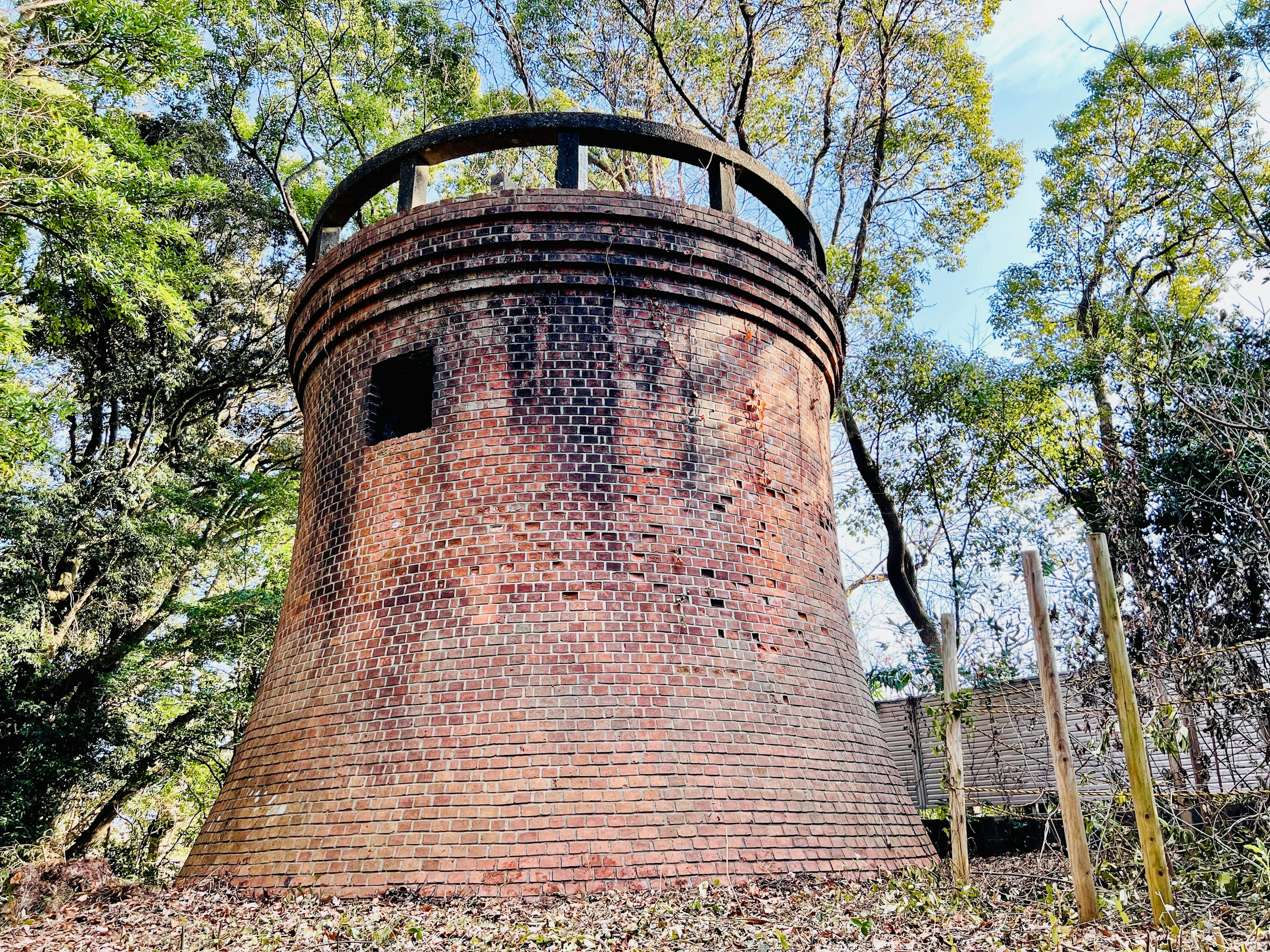 Ein alter Ziegelturm, umgeben von Bäumen