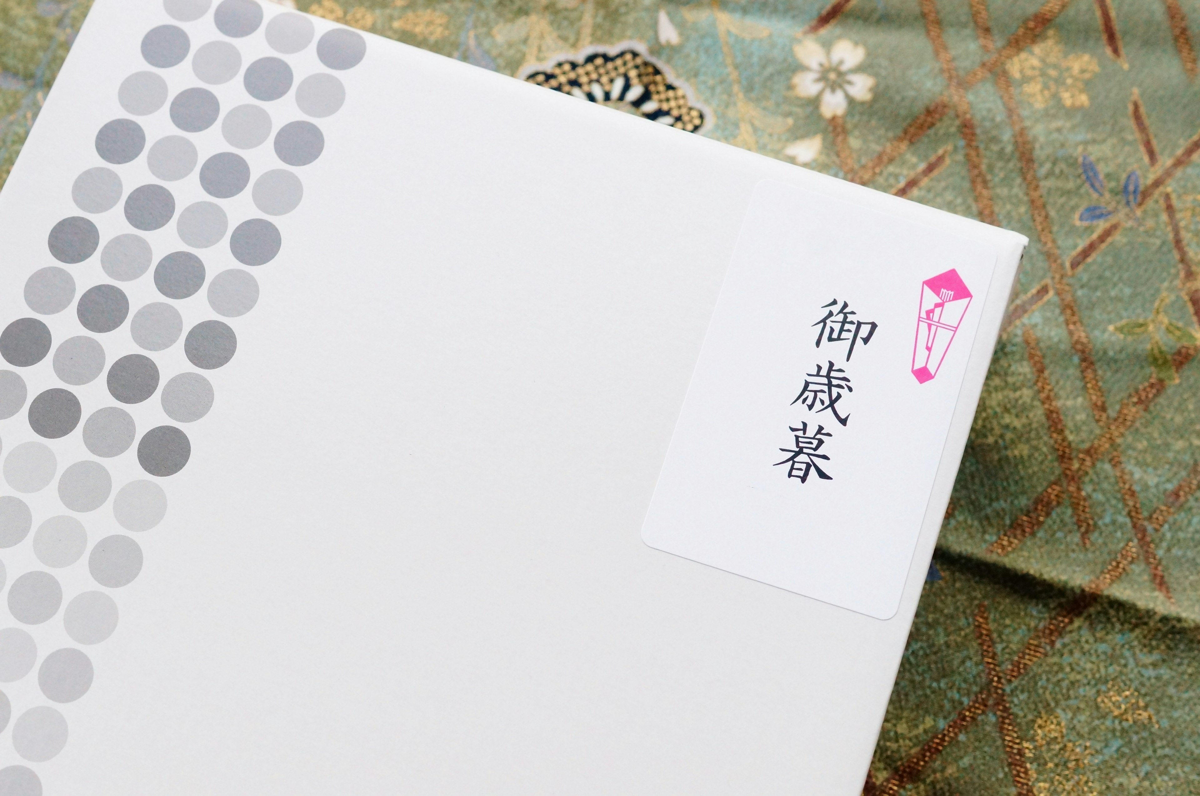 White envelope with gray dot pattern and red seal