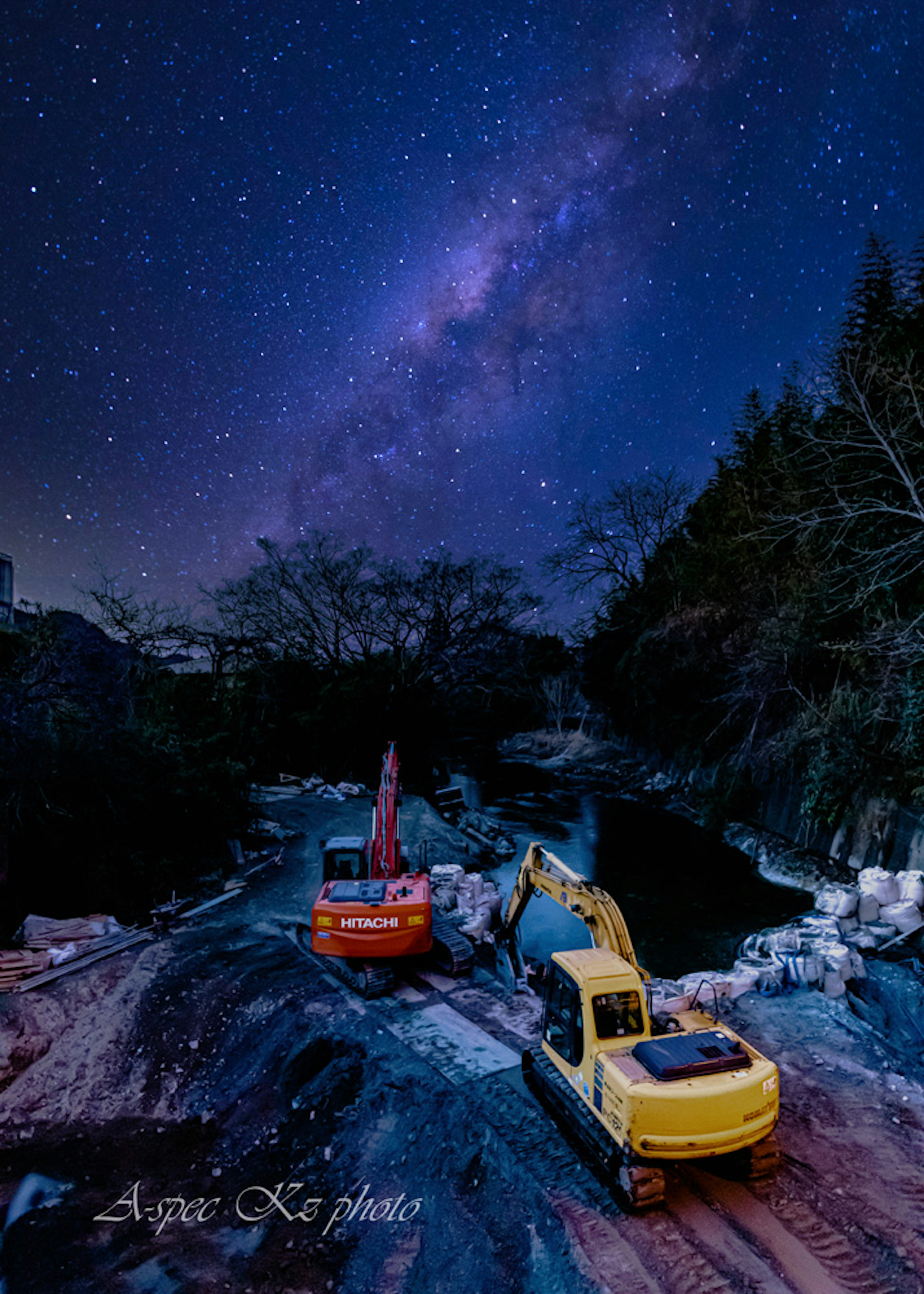 星空の下にある重機と川の風景