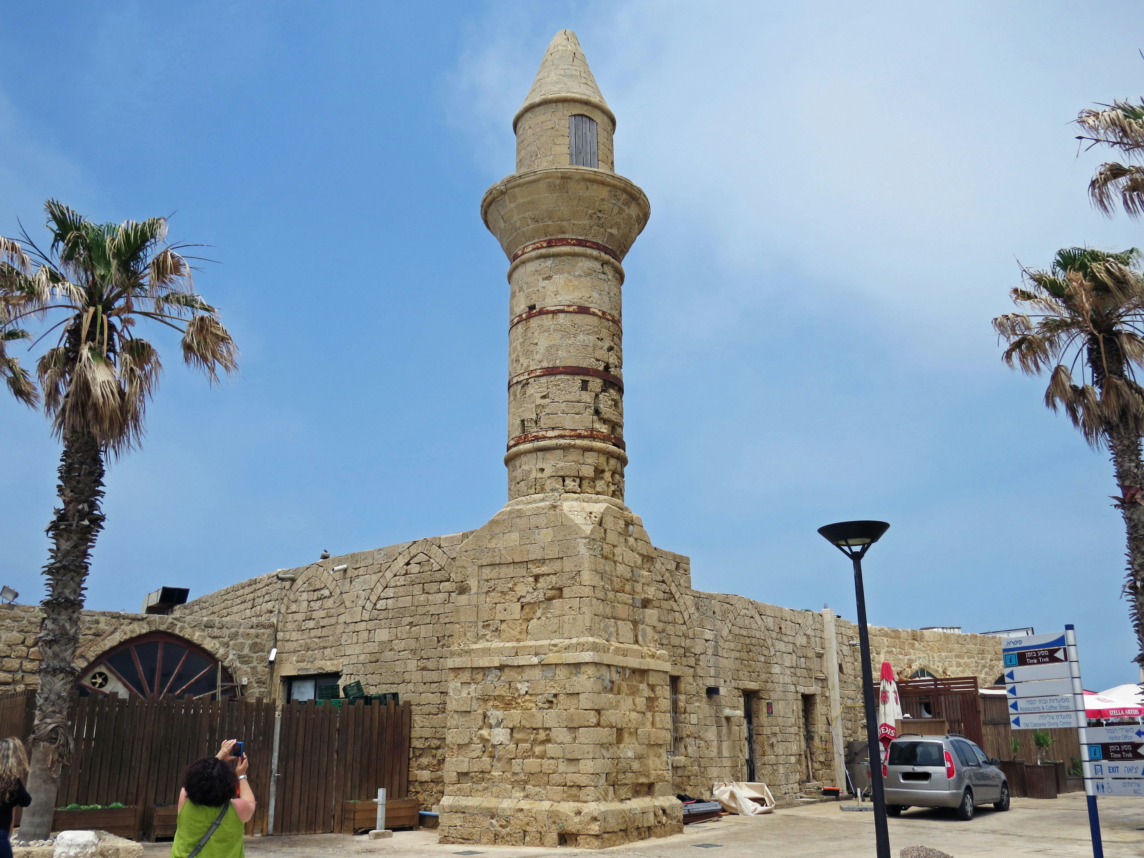 Minarete histórico con palmeras junto a la costa