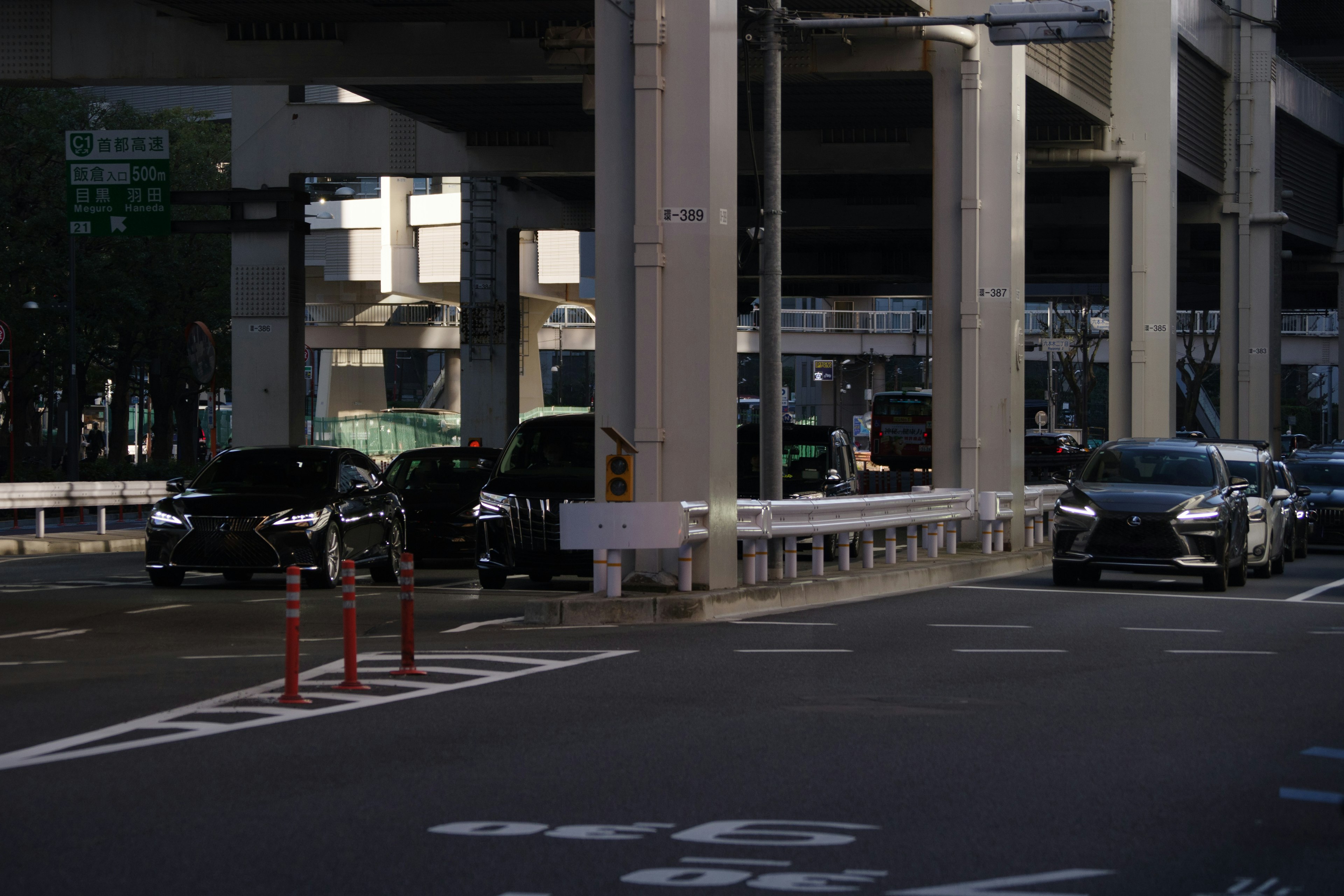 交差点の近くの都市の道路に停車した車両と高架の構造物