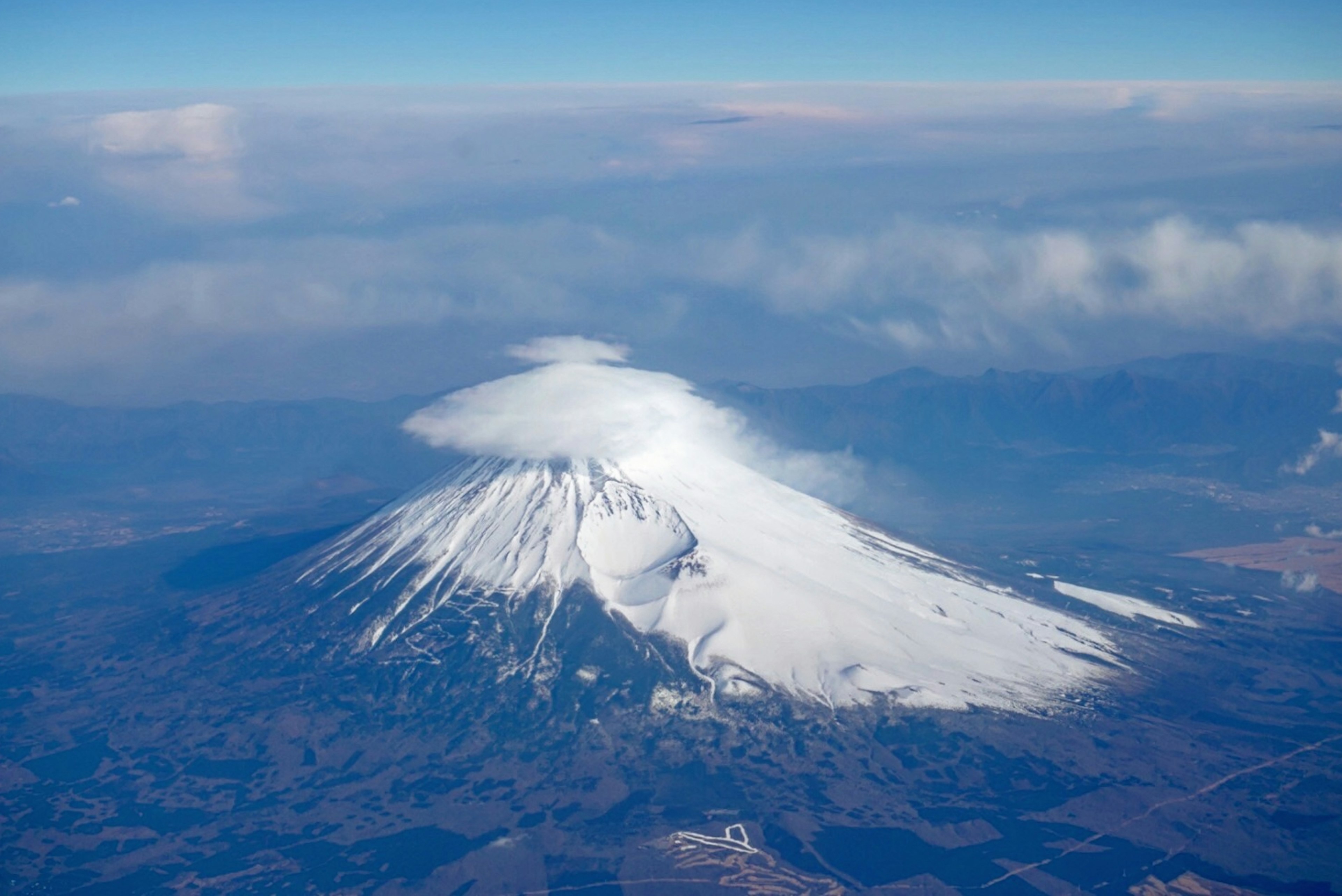 雪をかぶった山の頂上に雲がかかる美しい風景