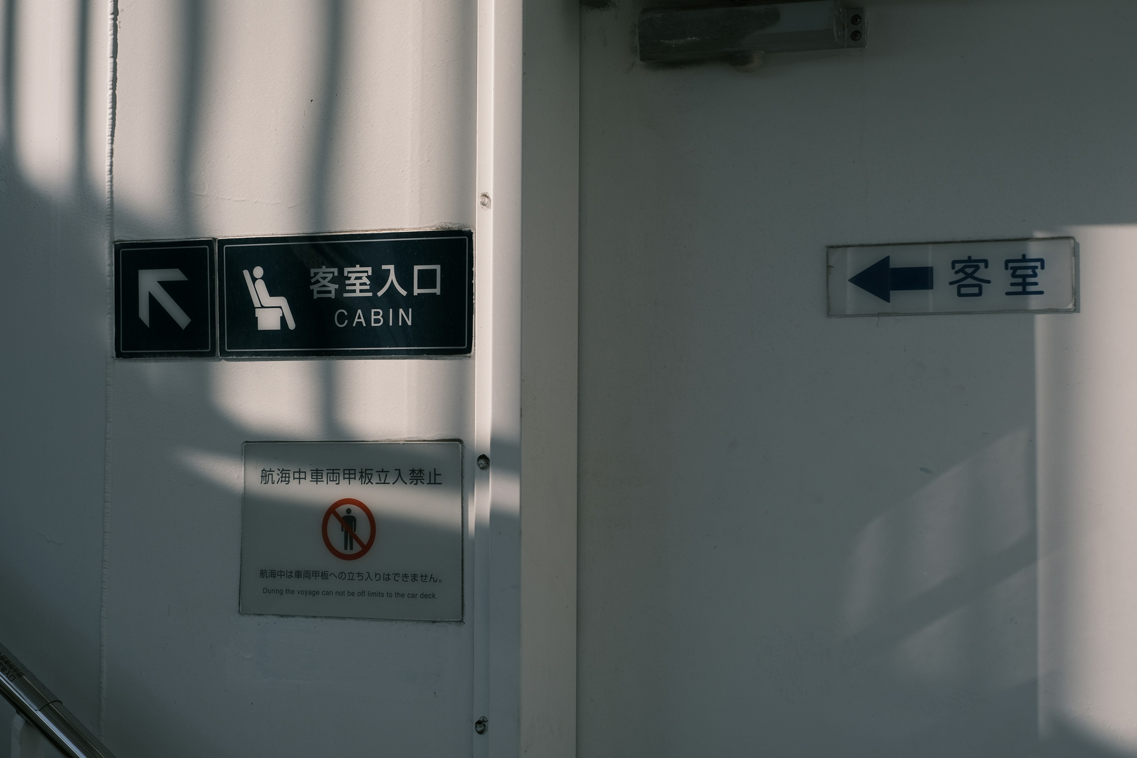 Panneaux sur un mur blanc indiquant l'entrée de la cabine et les toilettes