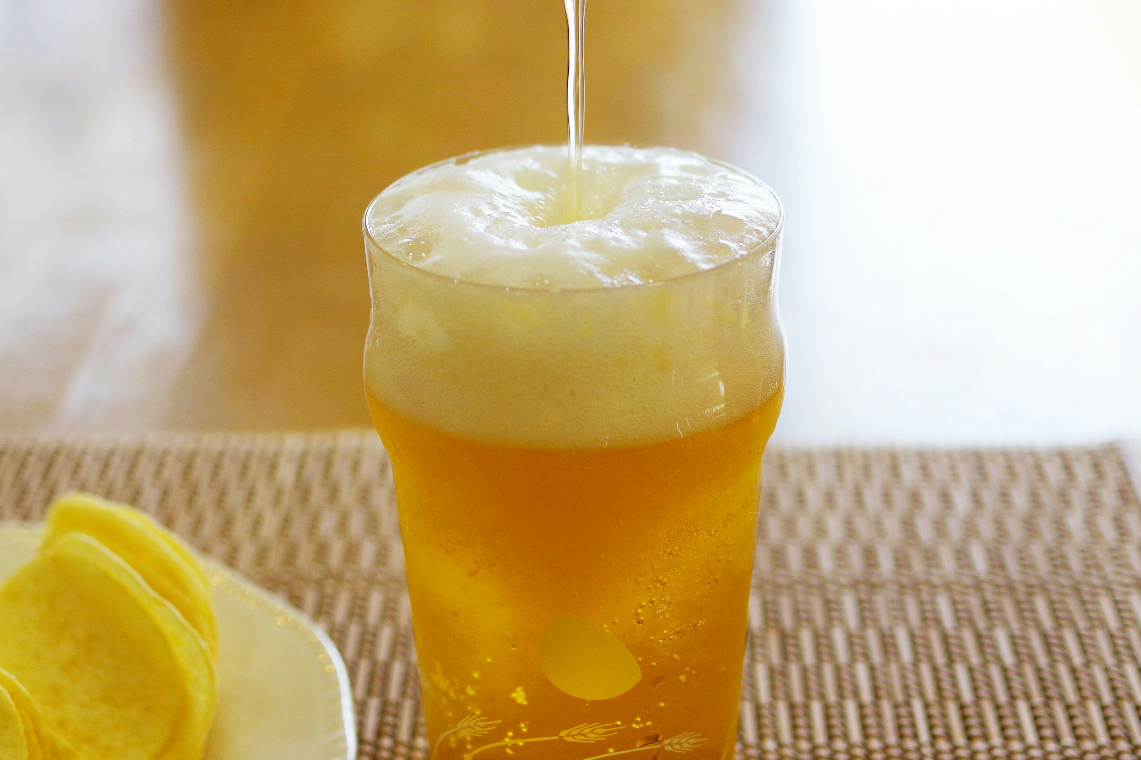 Vaso de cerveza espumosa con rodajas de limón al lado