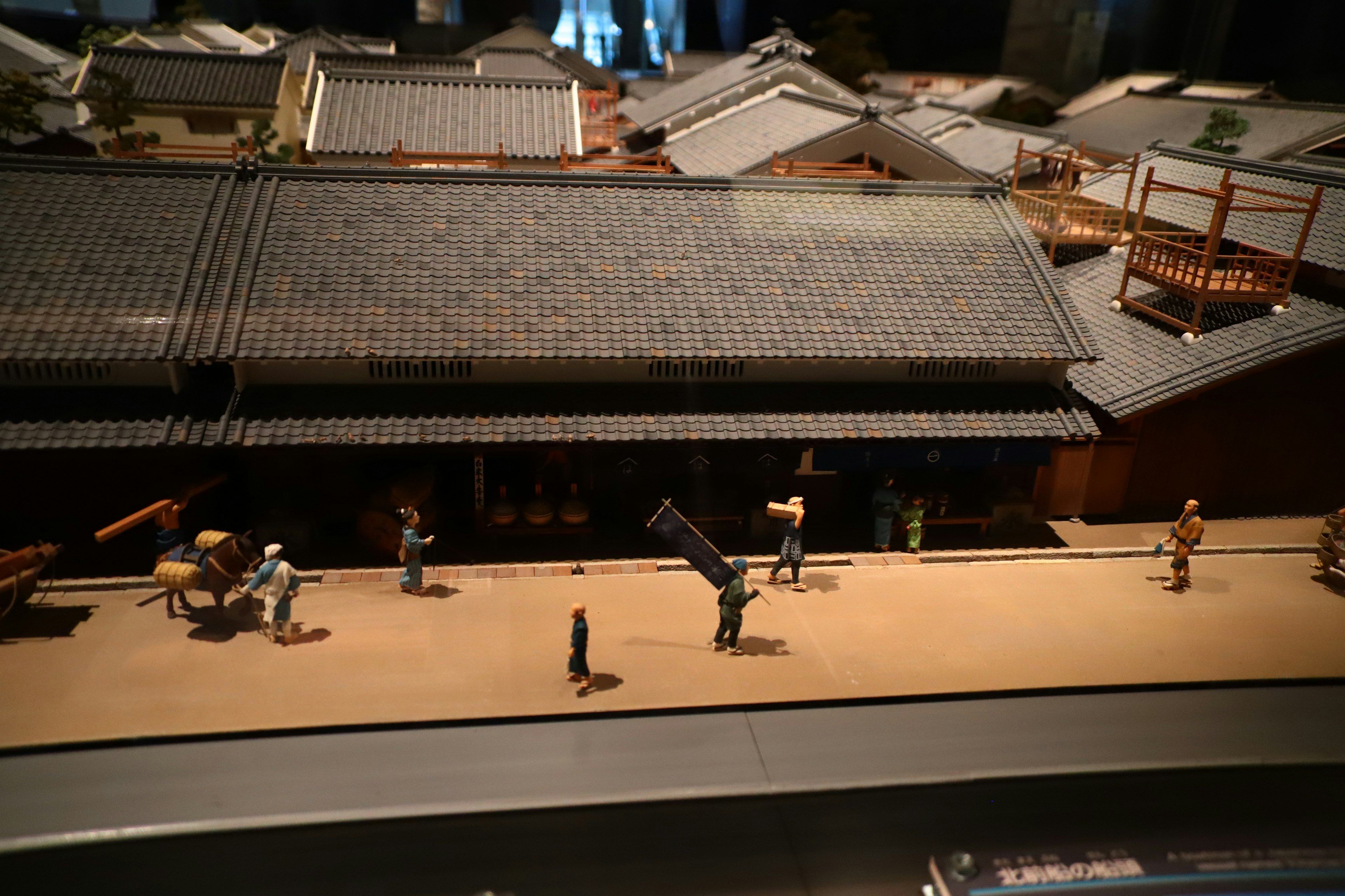 A miniature street scene with figurines and traditional architecture