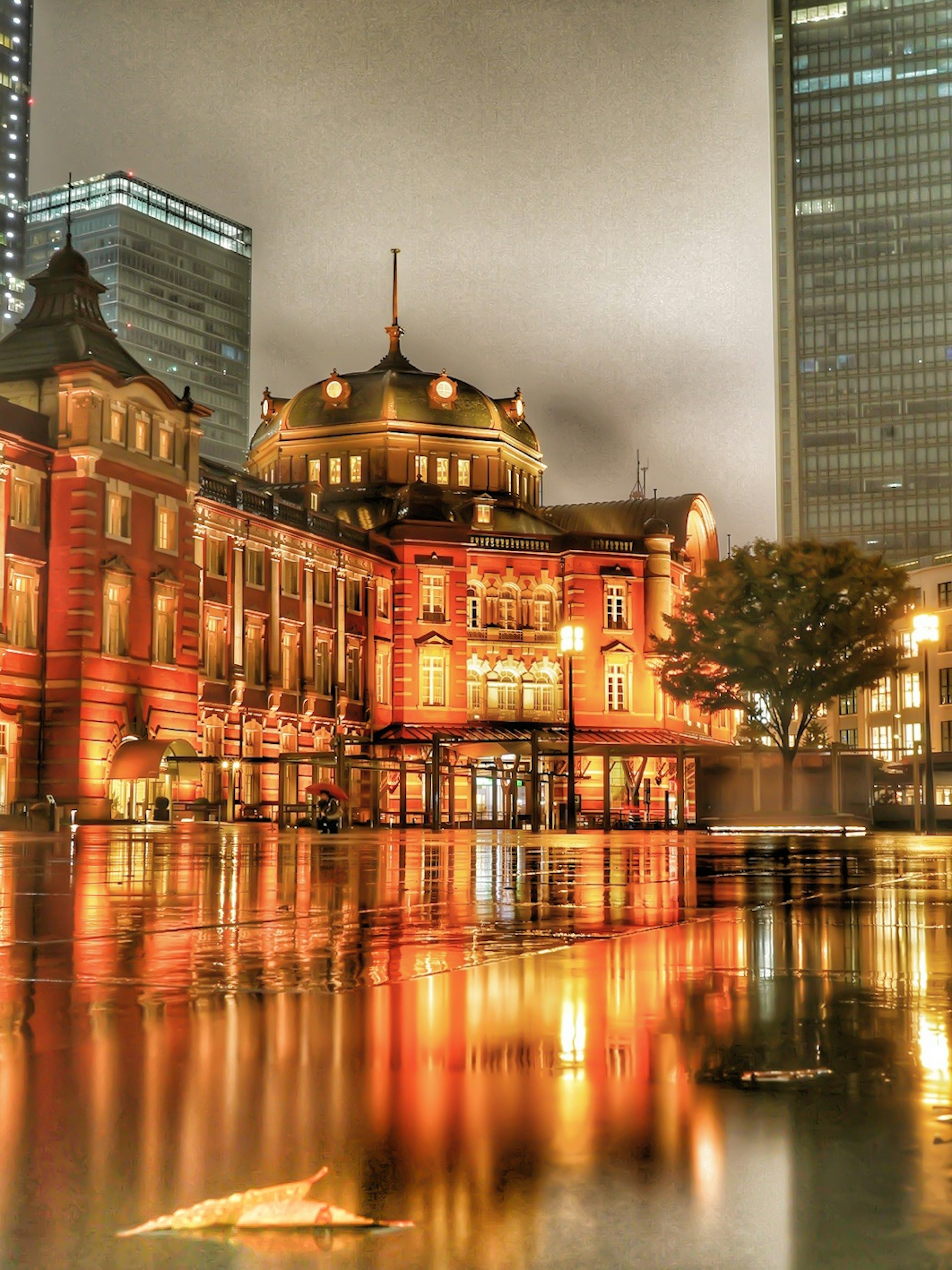 Tokio Station bei Nacht mit schöner roter Backsteinarchitektur und Wasserreflexion