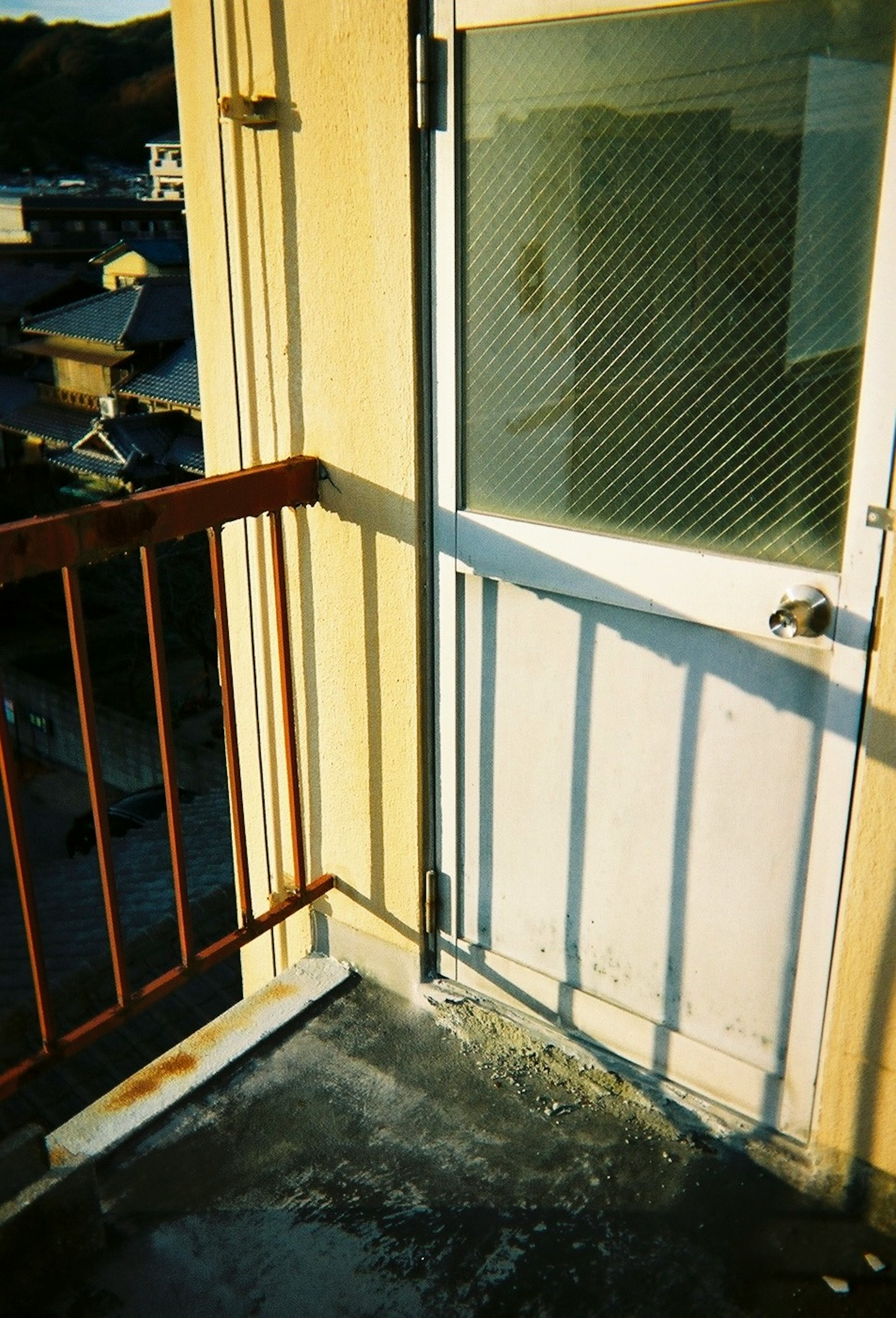 Image of a balcony door with railing showcasing bright colors and shadow contrast