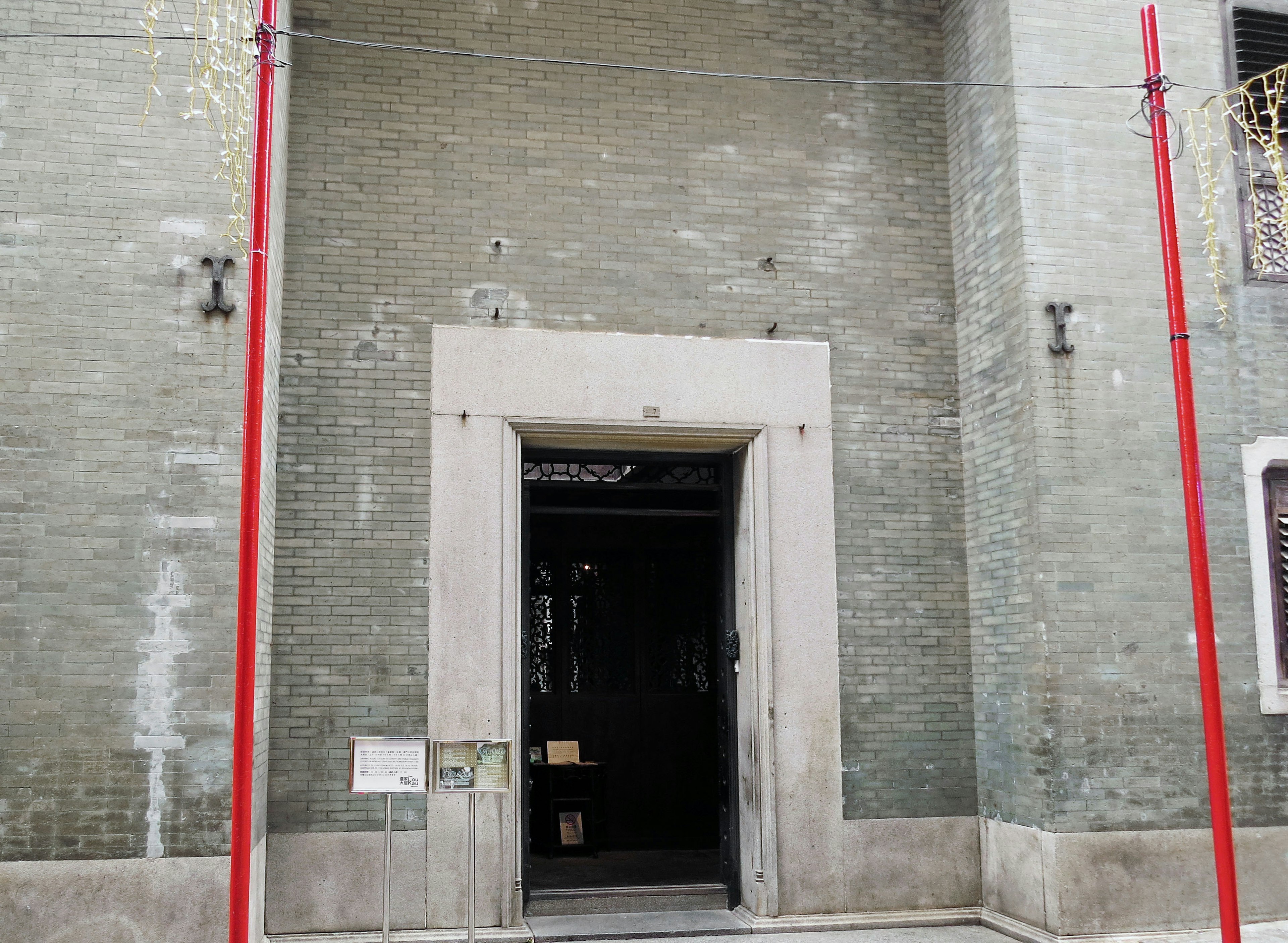 Entrée d'un bâtiment avec des murs verts et des piliers rouges