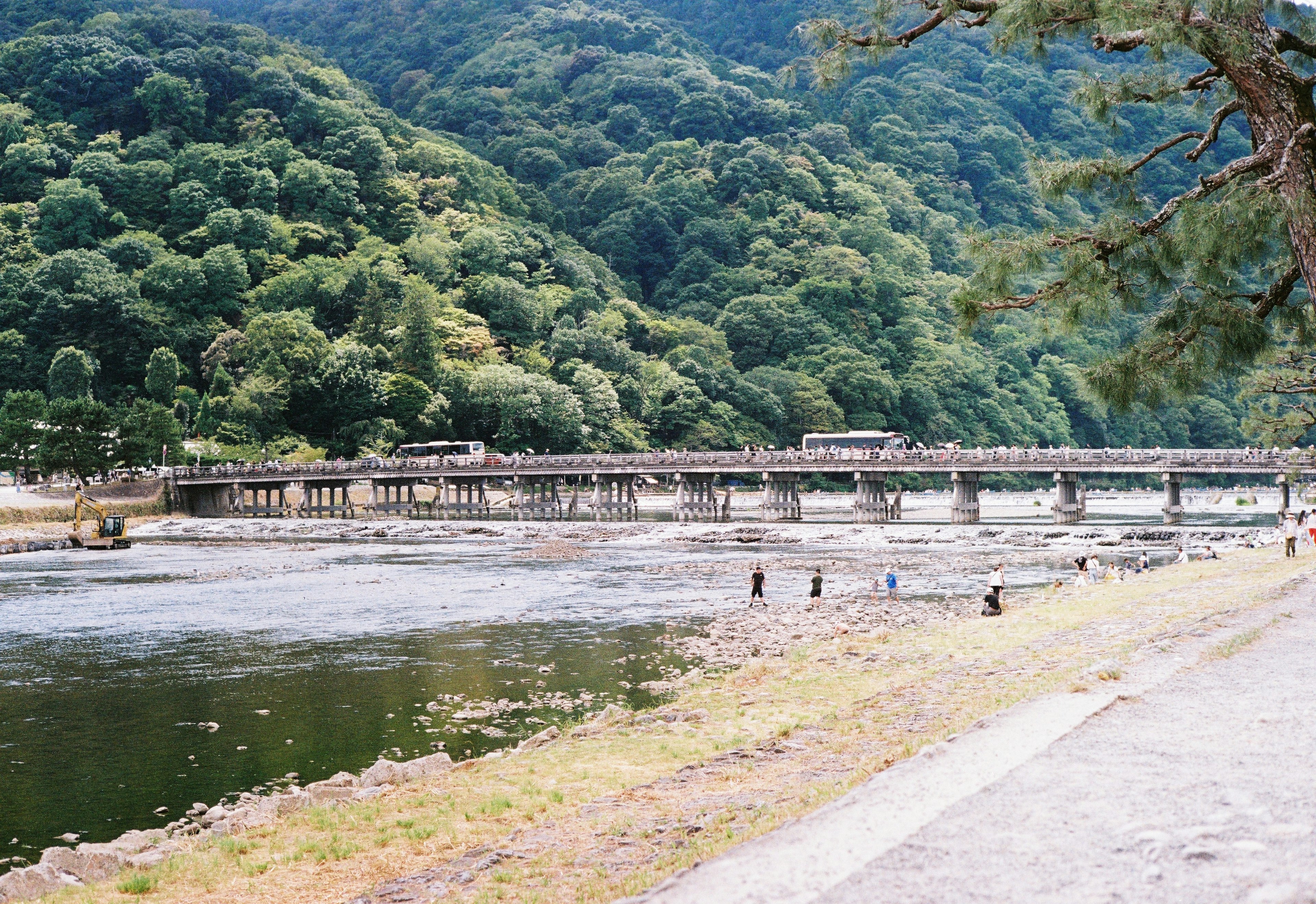 Scenic view of a river with a bridge surrounded by lush green mountains