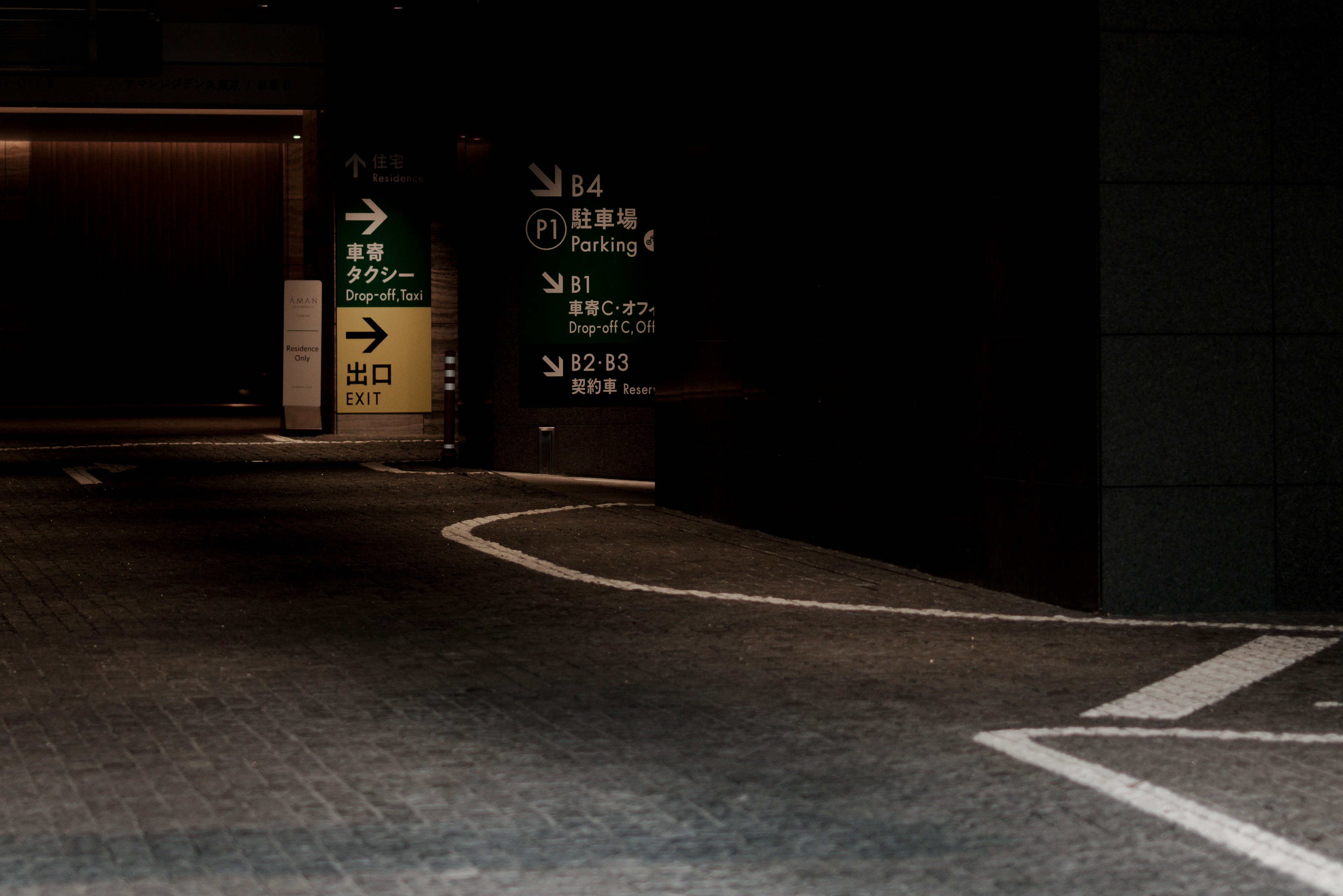 Entrata di un parcheggio poco illuminato con segnali direzionali