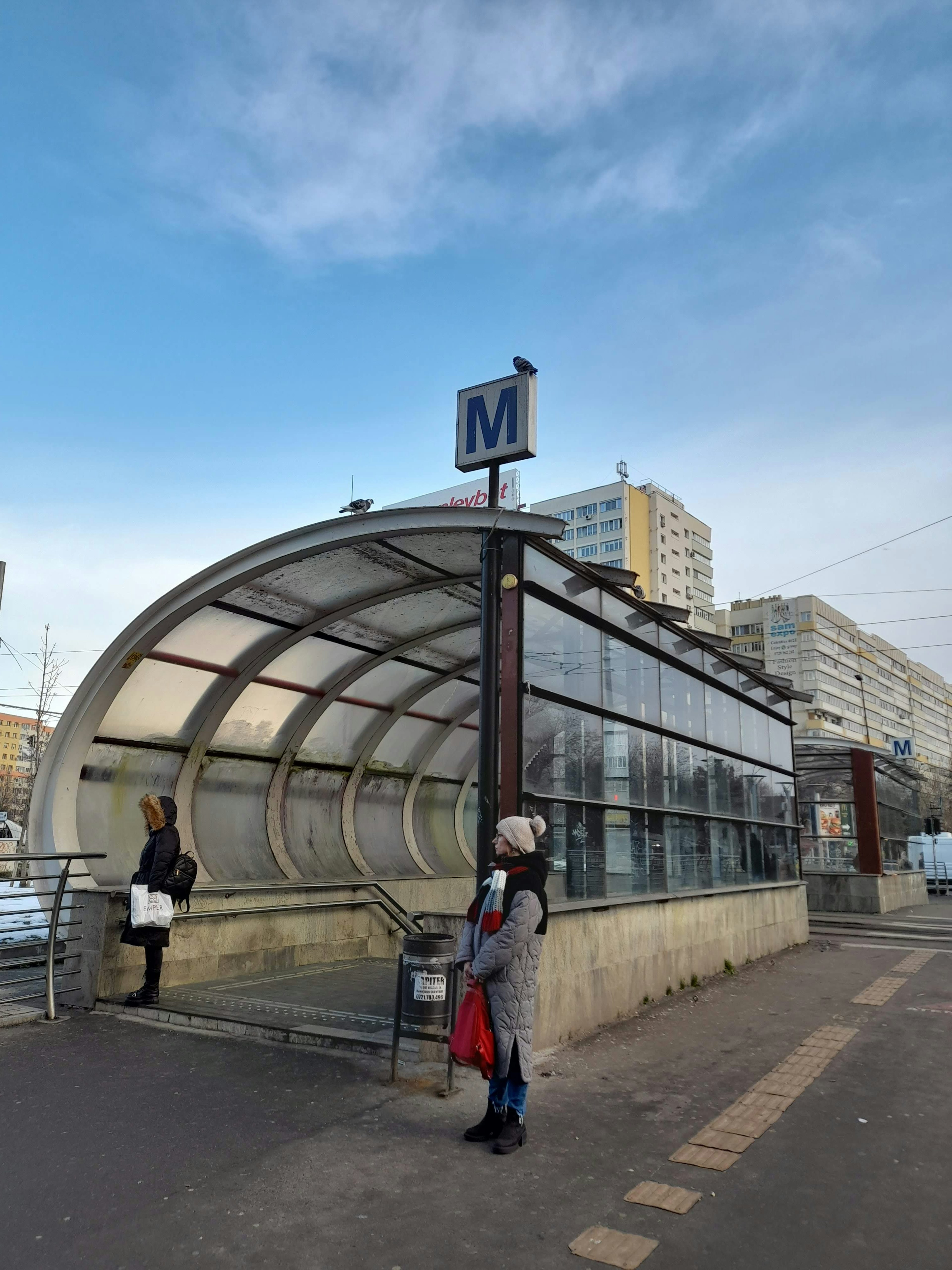 Fermata dell'autobus della metro dal design moderno Donna in attesa Vari edifici sullo sfondo