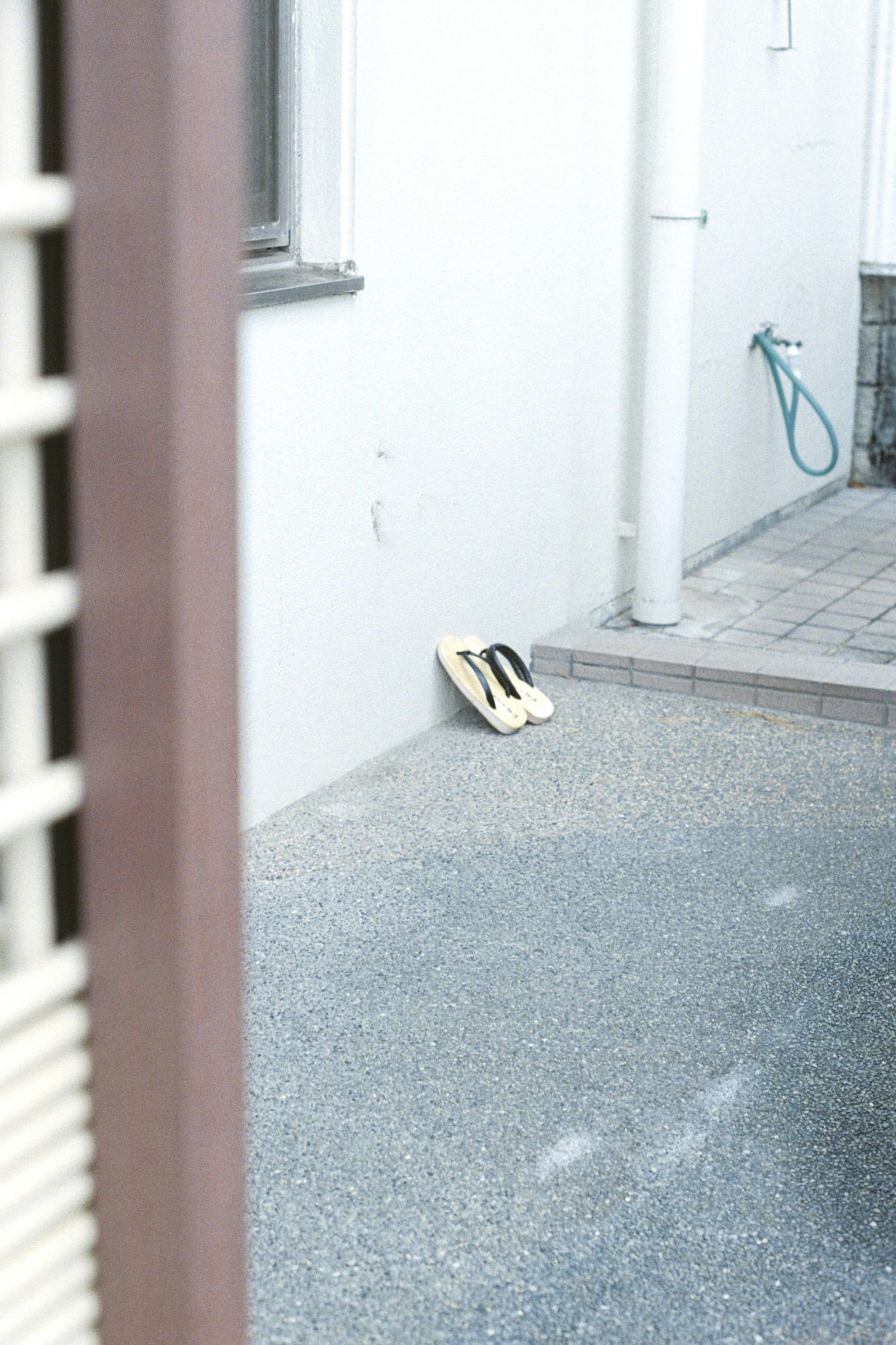 Zapatos negros y blancos colocados cerca de una pared blanca