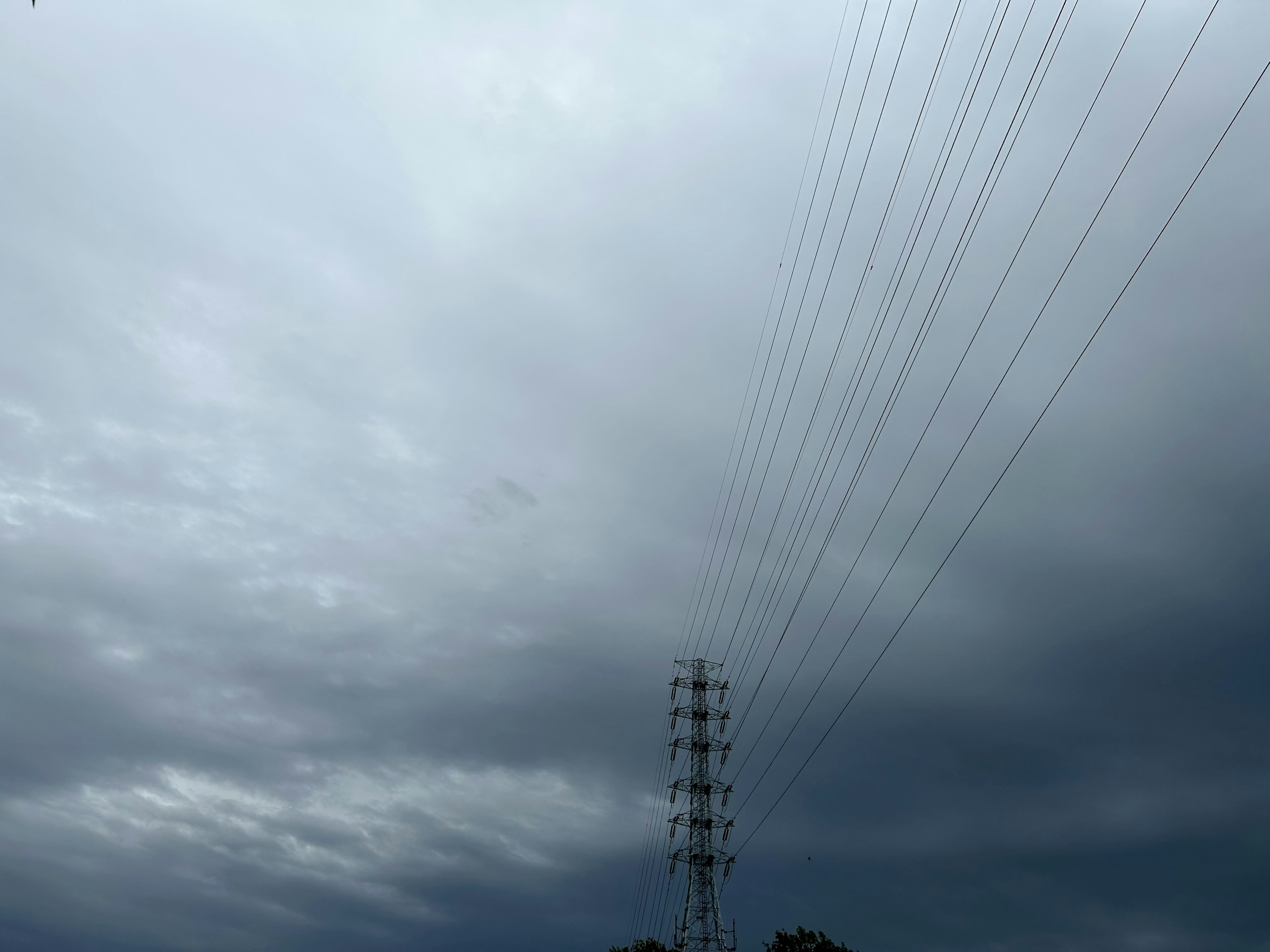 暗い雲に覆われた空と電柱が見える風景