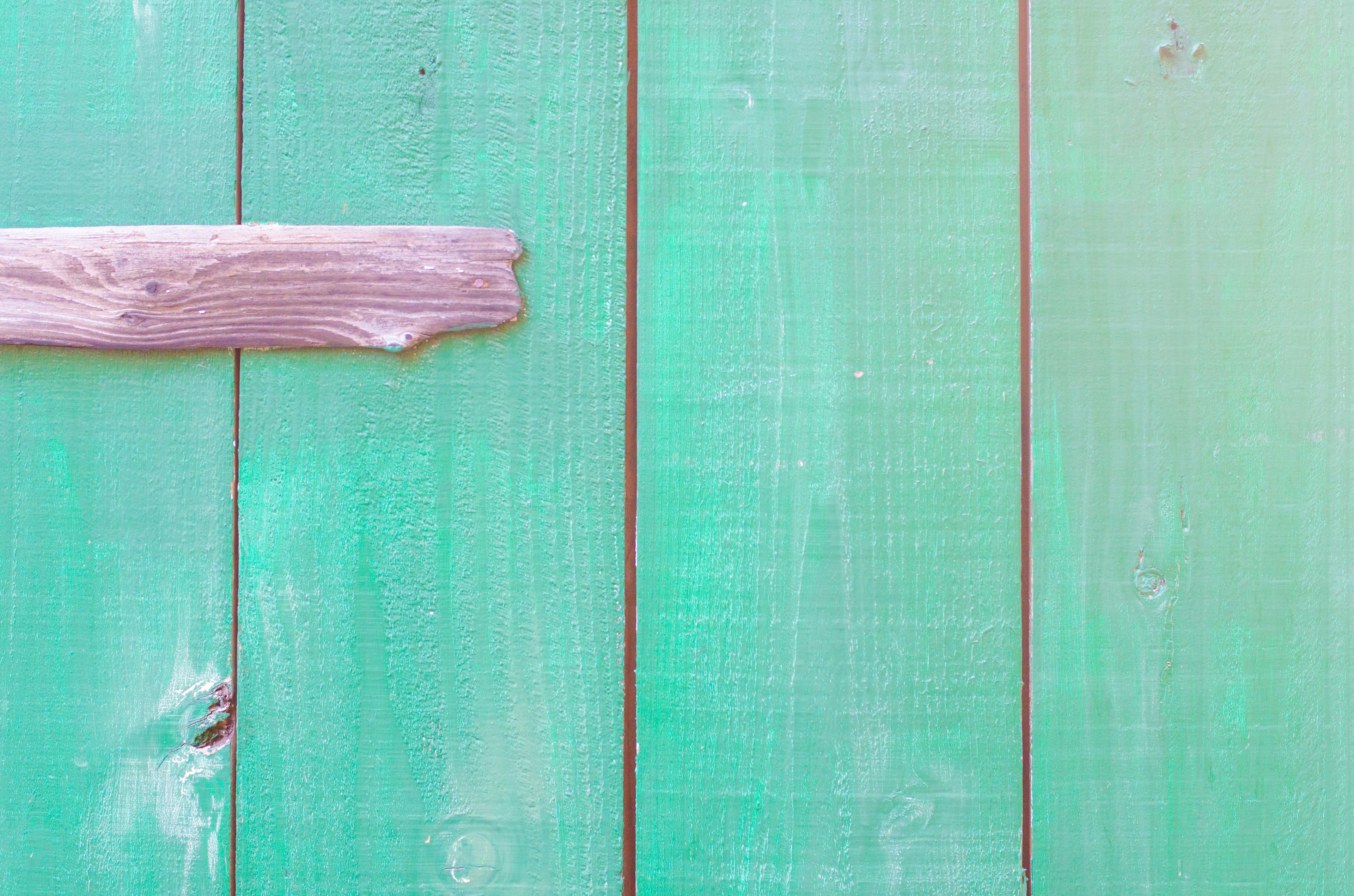 Green wooden panels with a pink wooden stripe across the surface