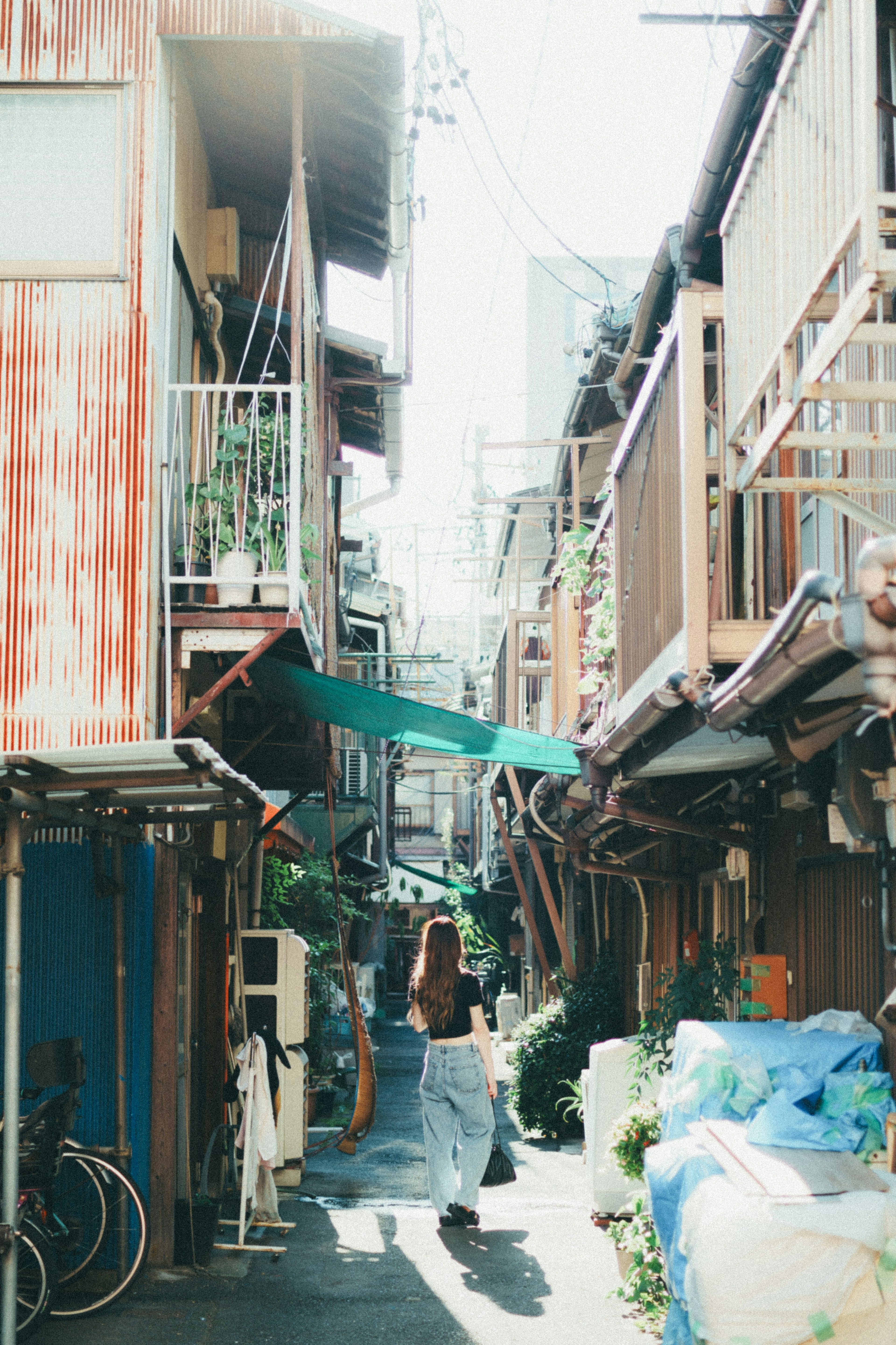 狭い路地を歩く女性と古い建物の風景